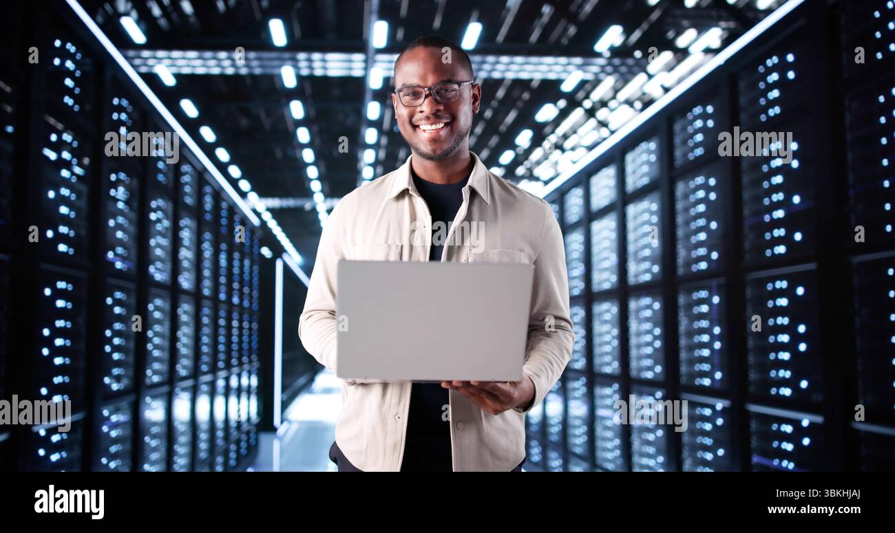 Technicien INFORMATIQUE souriant installant un système d'intelligence artificielle dans la salle des serveurs. Banque D'Images