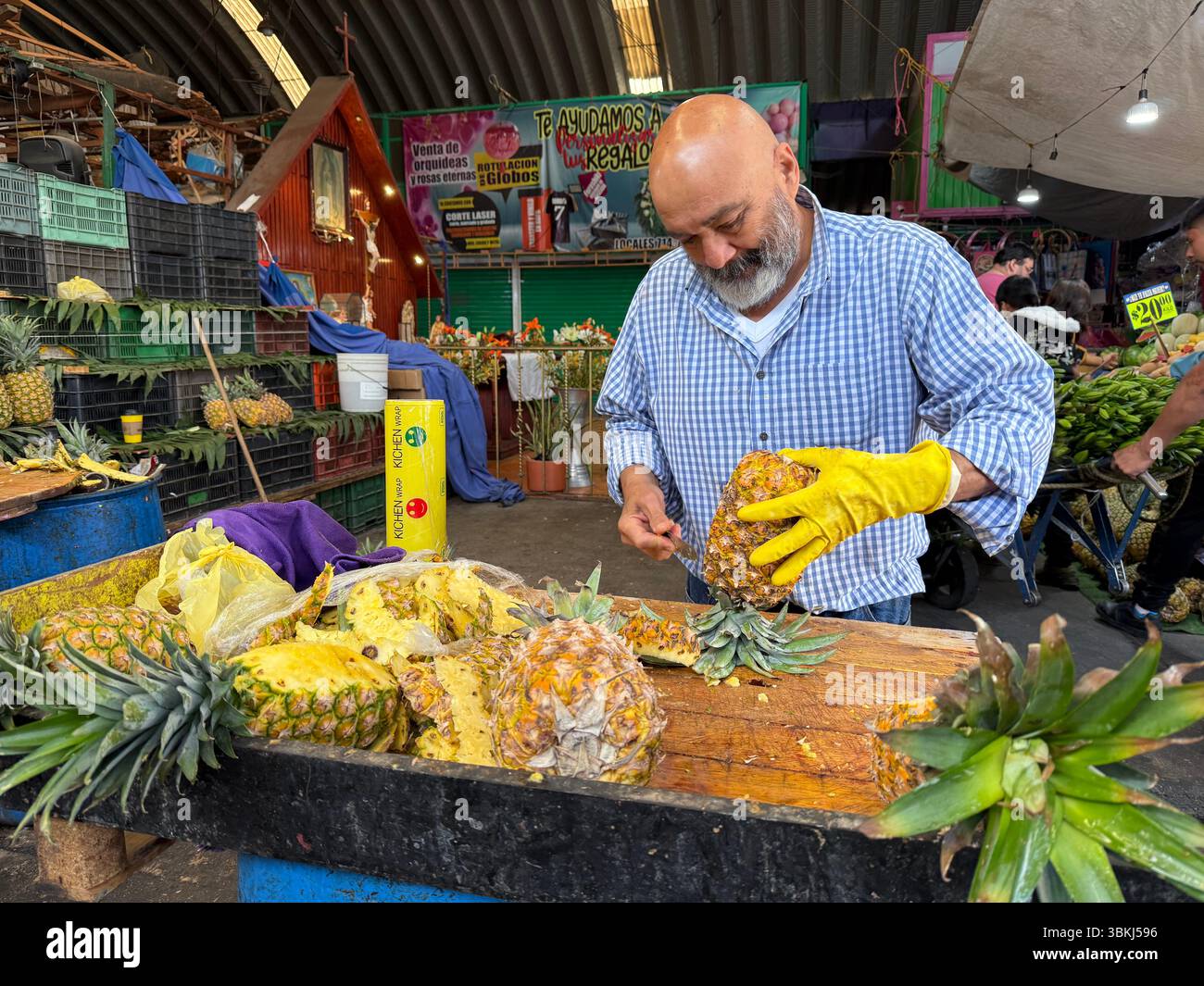 Vendeur coupant des ananas, Mercado Jamaica, l’un des marchés publics traditionnels de Mexico. CDMX, Mexique Banque D'Images