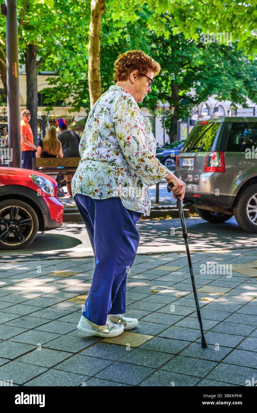 Femme âgée marchant lentement avec un bâton de marche - Tours, France. Banque D'Images