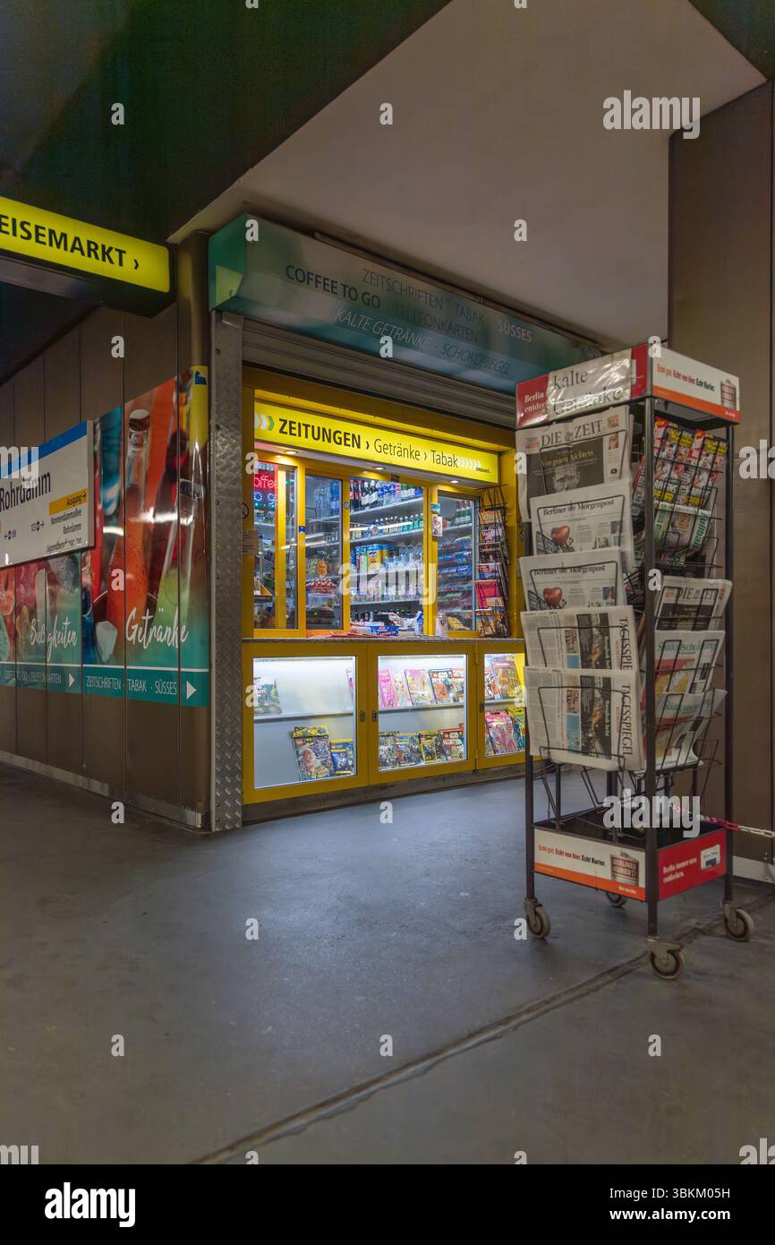 Kiosque jaune dans une station de métro vendant des journaux ('Zeitungen'), des boissons ('Getränke') et du tabac ('Tabak'). Commodité urbaine et nécessités quotidiennes Banque D'Images