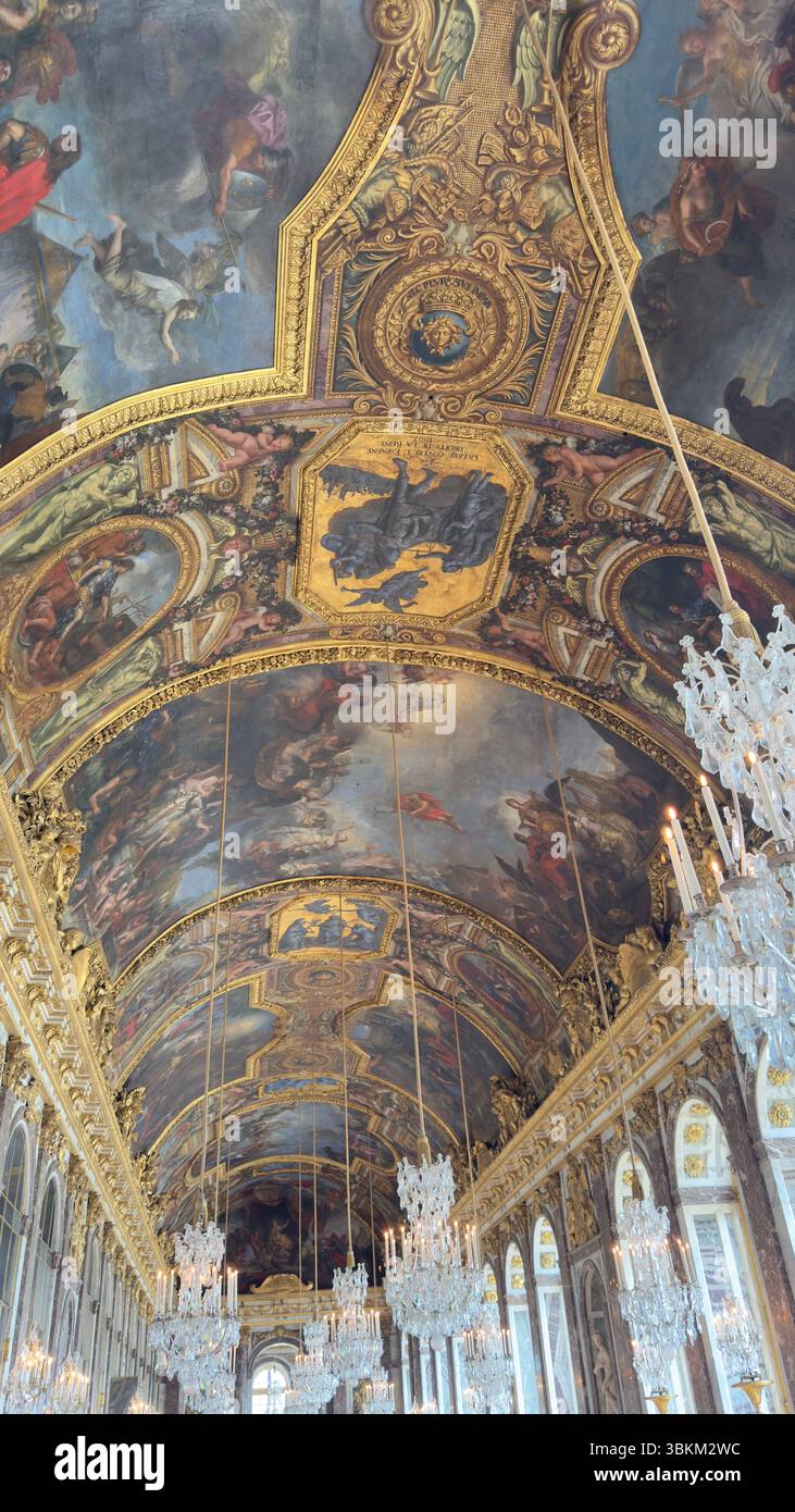 Plafond orné de figures peintes et de garnitures dorées, lustres suspendus au plafond dans une pièce aux murs en marbre. Banque D'Images