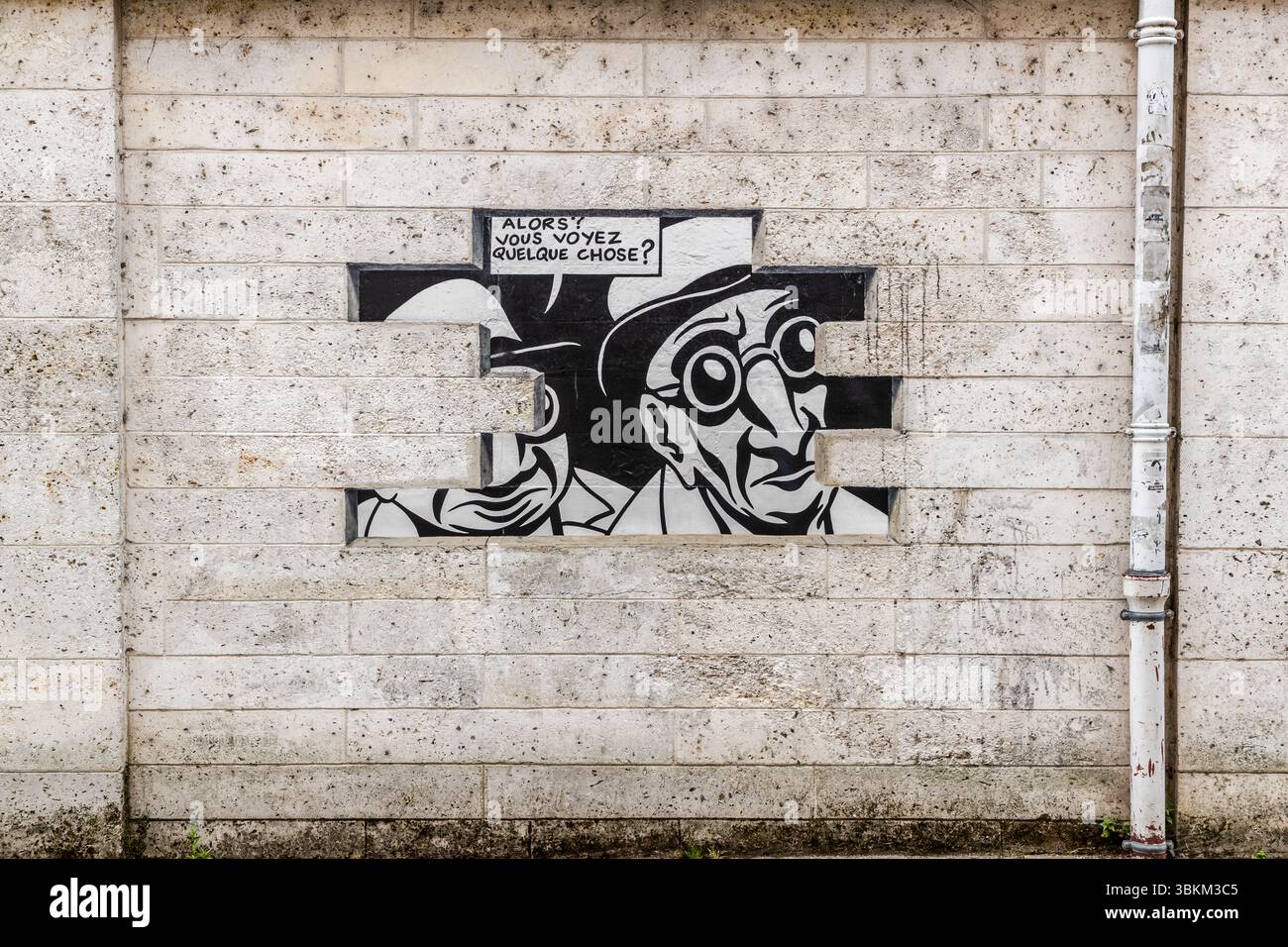 La fresque de la série "Réalité, Sortie de Secours", conçue par Marc-Antoine Mathieu, représente des personnages de bandes dessinées avec des bulles de dialogue qui semblent éclater du mur, Rue de Beaulieu, Angoulême, Nouvelle-Aquitaine, France. Dans ce panneau, deux hommes chapeautés regardent à travers une fissure dans le maçonnerie peinte. La bulle de dialogue dit "Alors? Vous voyez quelque chose?" En anglais : "So? Do you see anything?" En six panneaux, la série raconte une histoire complète : "Do you see anything? Yes, look. It's exactly what I feared. What, another underworld? Worse than that. It's rea Banque D'Images