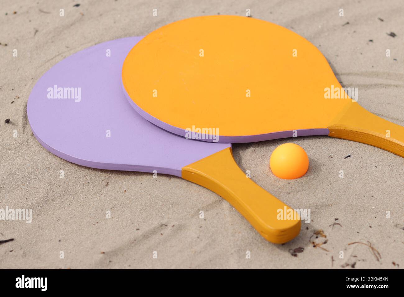 Raquettes de tennis de plage et balle sur sable. Mode de vie actif, jeux et sports. Set de tennis de plage. Raquettes en bois vif pour les jeux de plein air. Été extérieur g Banque D'Images