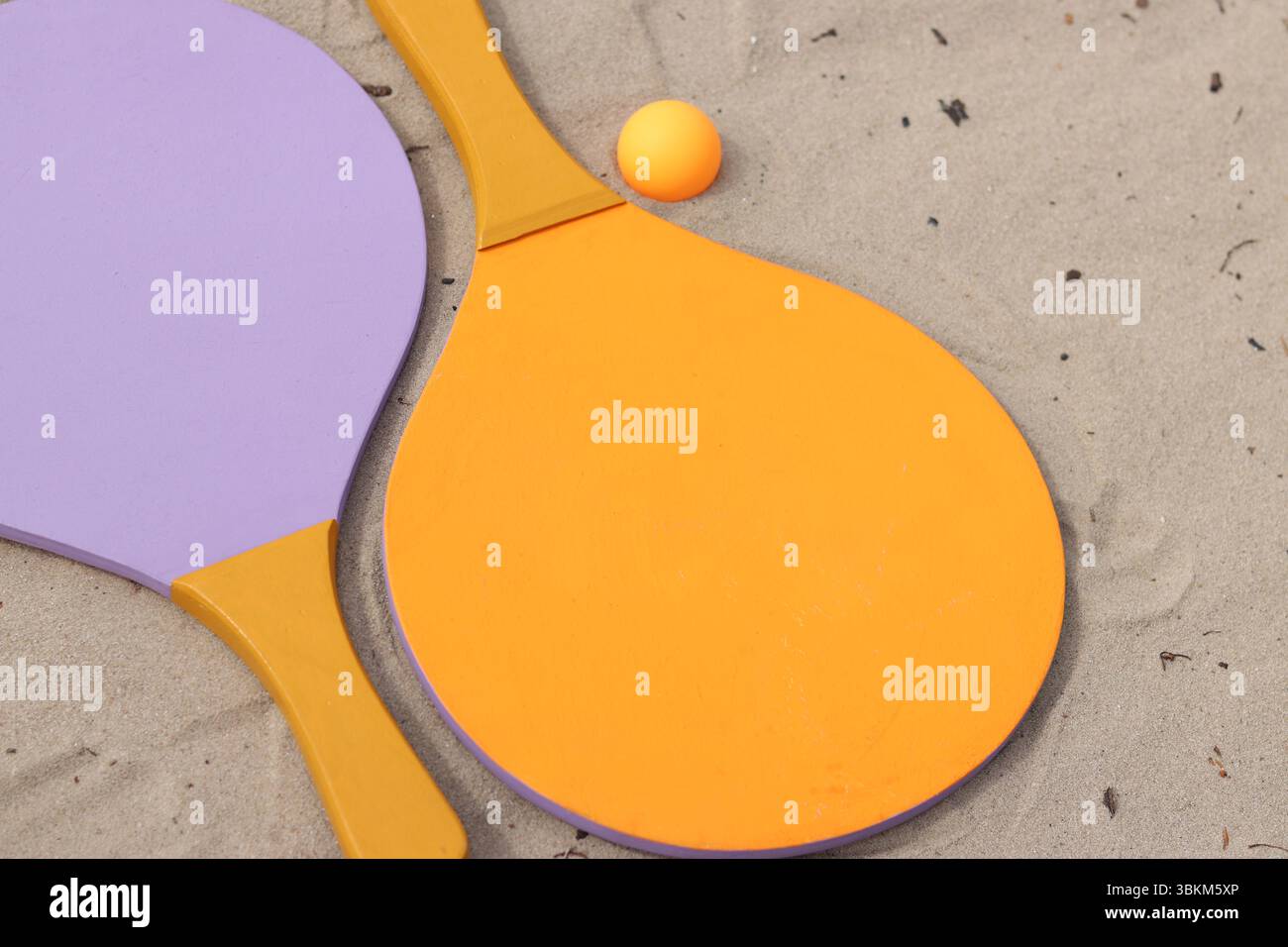 Raquettes de tennis de plage et balle sur sable. Mode de vie actif, jeux et sports. Set de tennis de plage. Raquettes en bois vif pour les jeux de plein air. Été extérieur g Banque D'Images