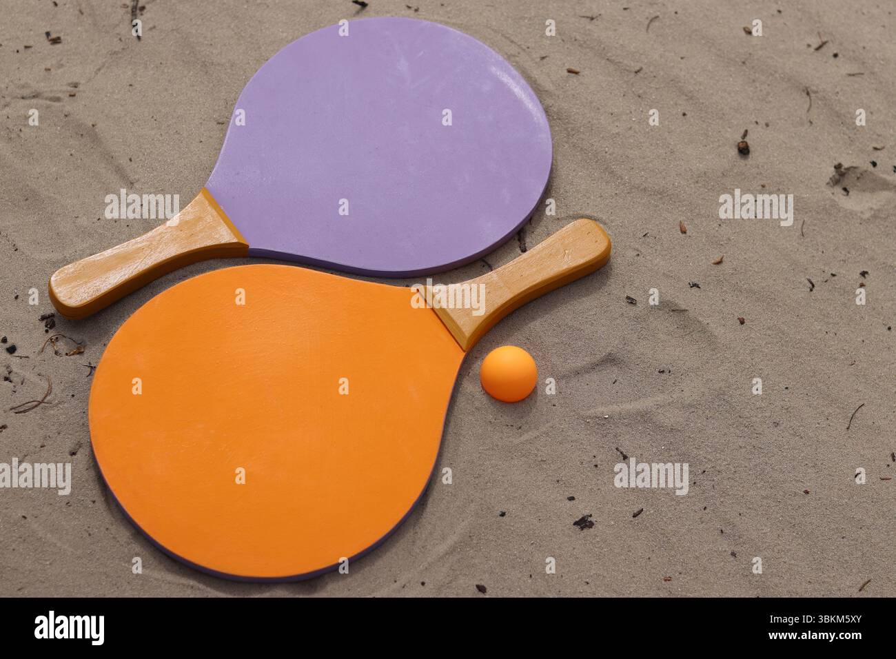 Raquettes de tennis de plage et balle sur sable. Mode de vie actif, jeux et sports. Set de tennis de plage. Raquettes en bois vif pour les jeux de plein air. Été extérieur g Banque D'Images