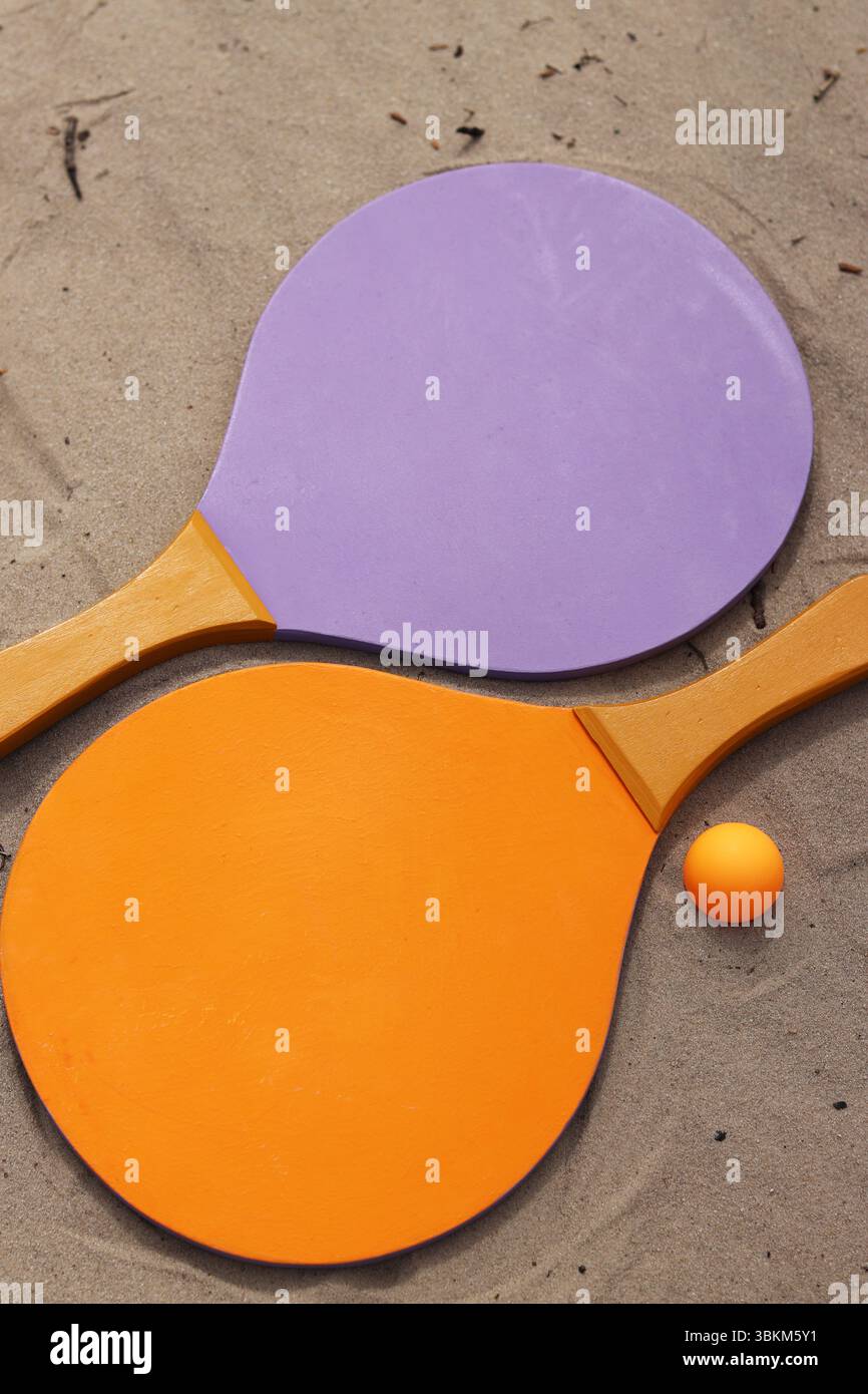 Raquettes de tennis de plage et balle sur sable. Mode de vie actif, jeux et sports. Set de tennis de plage. Raquettes en bois vif pour les jeux de plein air. Été extérieur g Banque D'Images