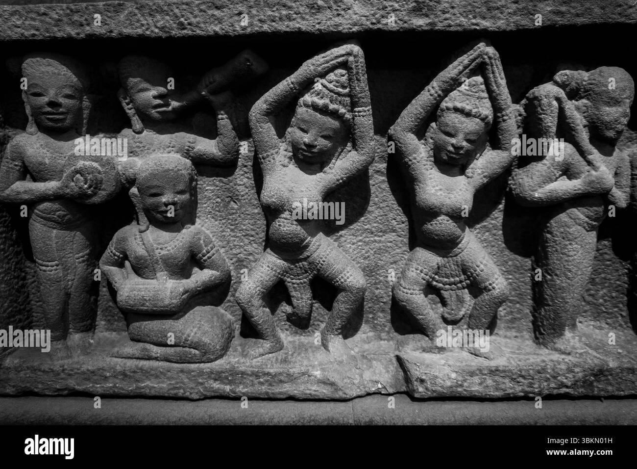 Groupe de statues de femmes et d'hommes. L'une des femmes tient un bol. Les statues sont toutes en noir et blanc Banque D'Images