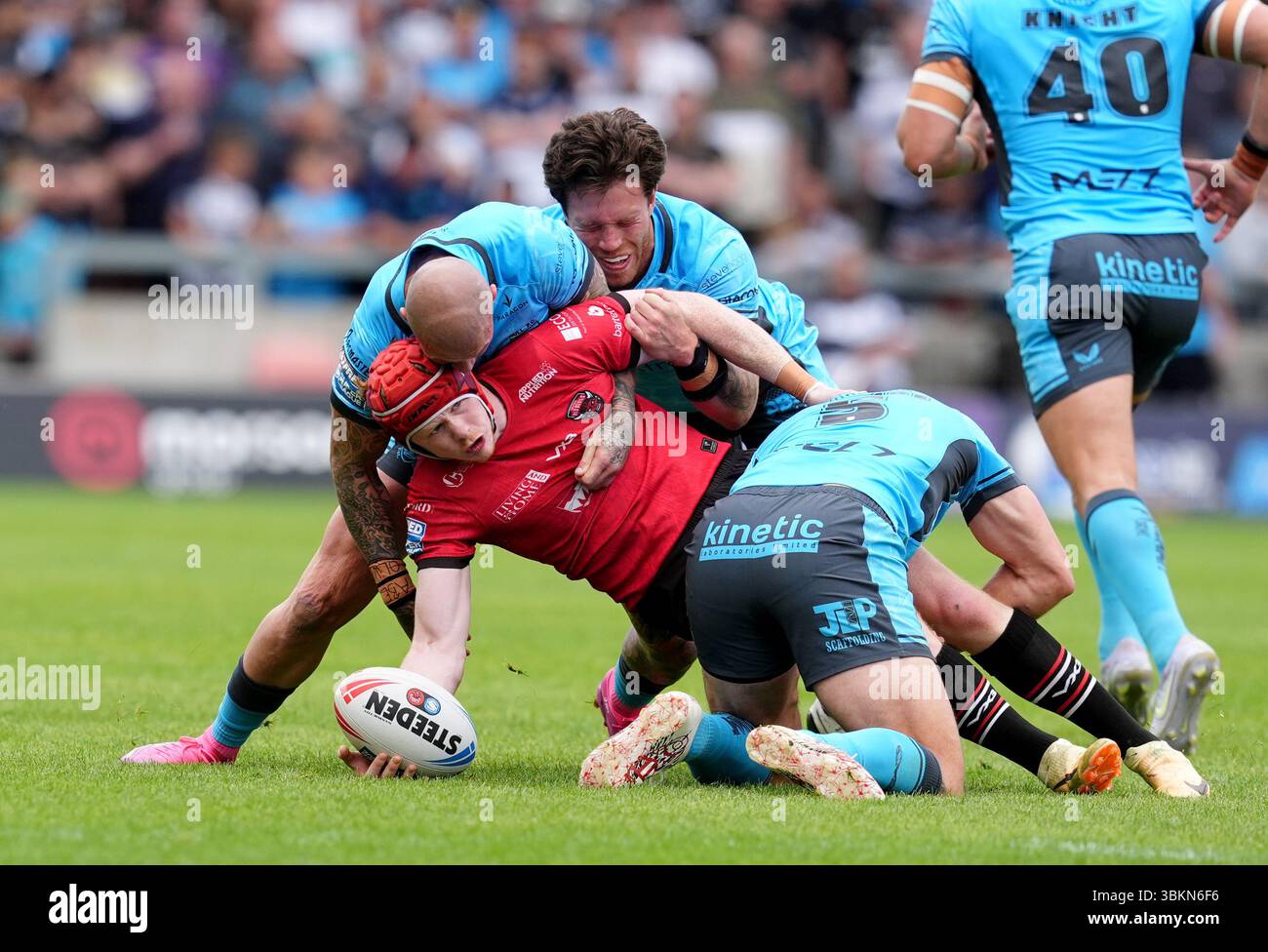 Jonny Vaughan de Salford est attaqué par Zak Hardaker de Hull (à gauche) et Tom Briscoe (à droite) lors du match de Super League de Betfred au Salford Community Stadium. Date de la photo : dimanche 22 juin 2025. Banque D'Images