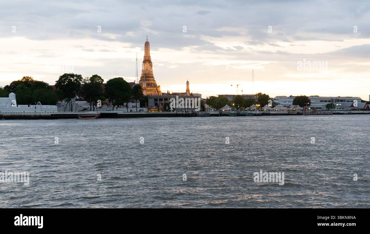 Temple Wat Arun au coucher du soleil de l'autre côté de la rivière Chao Phraya Banque D'Images