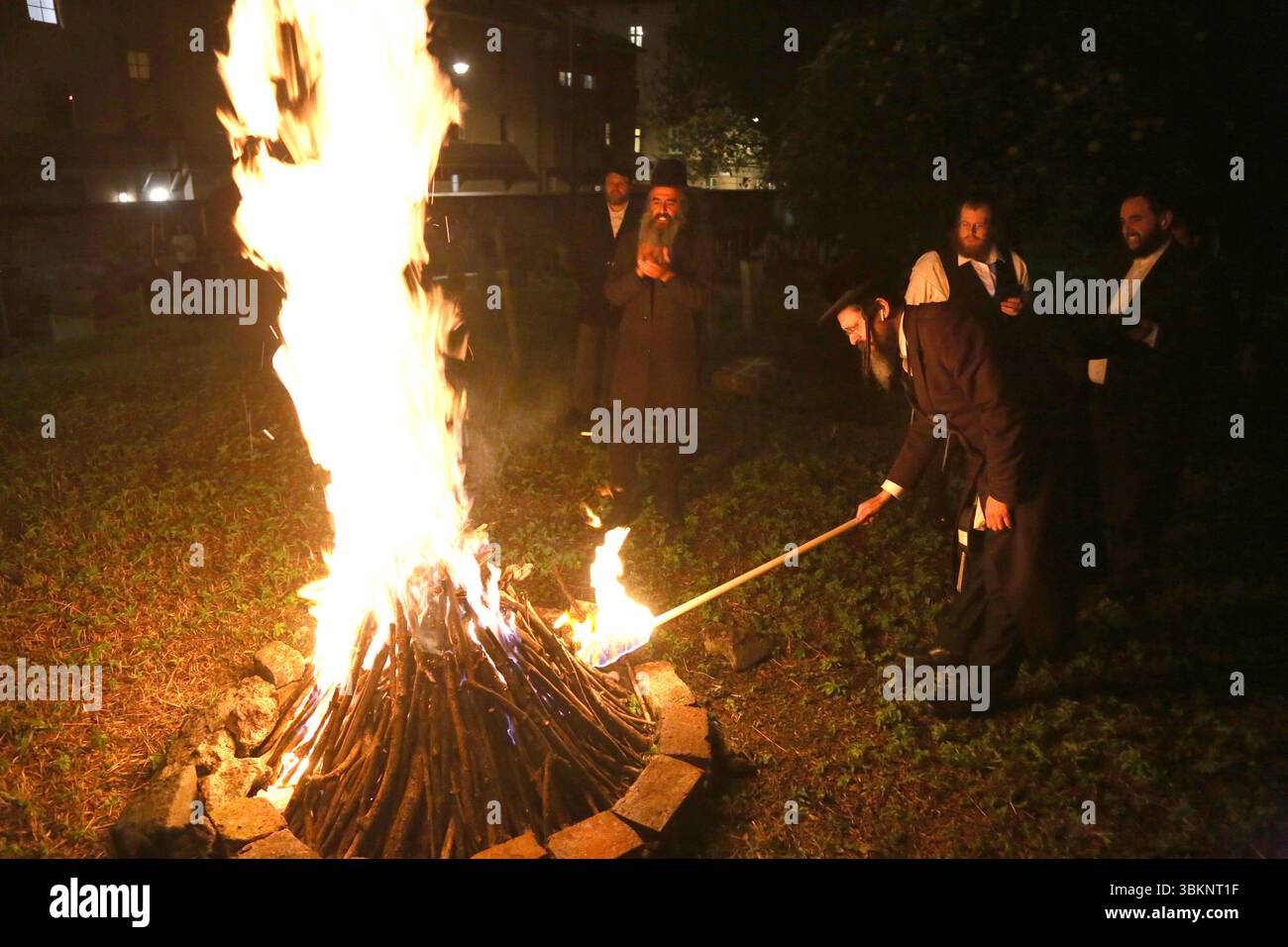 Cracovie. Cracovie. Pologne. Juifs orthodoxes célébrant la fête de Lag Ba-Omer faisant feu de joie et dansant autour de lui vu au cimetière Remuh à Kazimi Banque D'Images