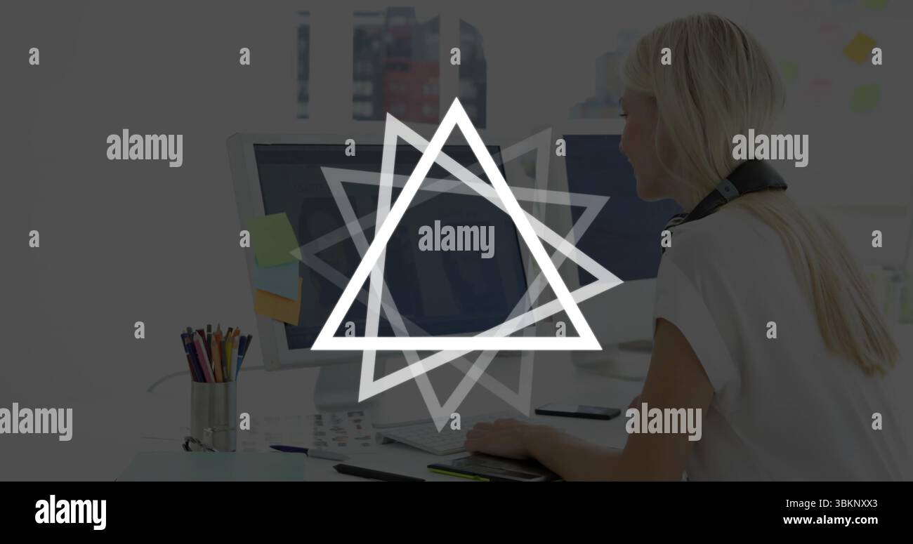 Dessiner femme à l'aide d'une tablette graphique dans le bureau, avec deux moniteurs et smartphone, espace de copie Banque D'Images