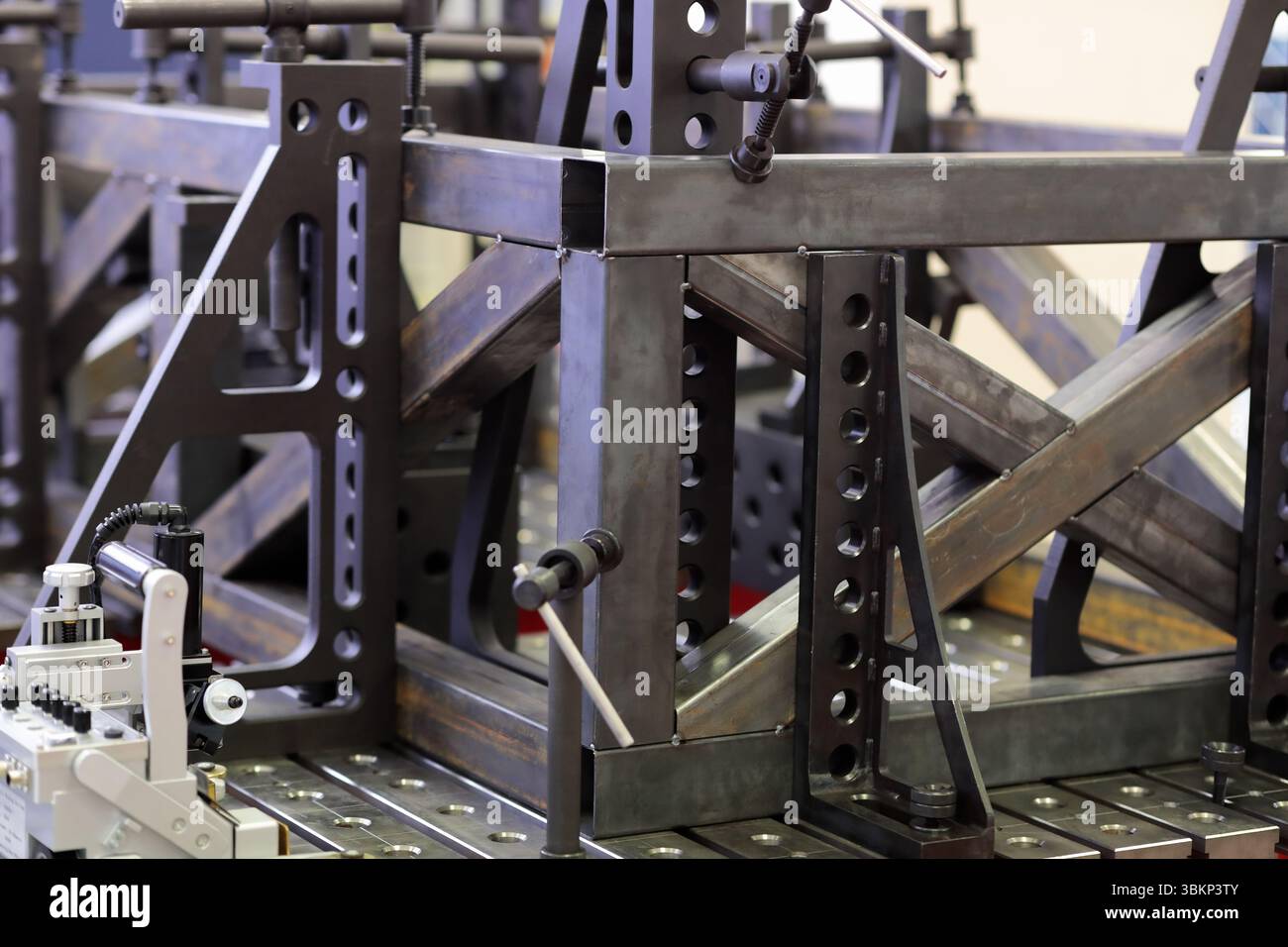 Cadre en acier sur table de soudage modulaire avec fixations. Mise au point sélective. Banque D'Images