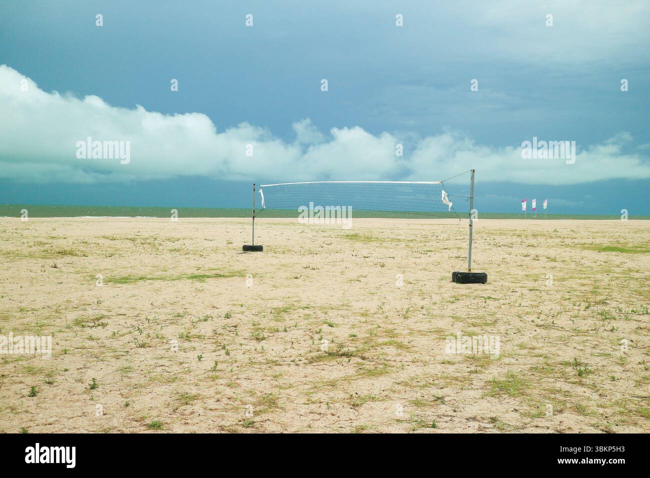 Terrain de Beach volley vide sous un ciel bleu vif avec des nuages éparpillés. Côte tropicale sereine en Asie du Sud-est. Banque D'Images