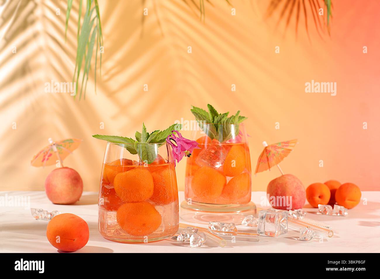 Thé de pêche glacé ou cocktail à la menthe et aux abricots, recette rafraîchissante de boisson estivale. Deux verres avec limonade aux fruits de pêche sur une table lumineuse, régime détox Banque D'Images