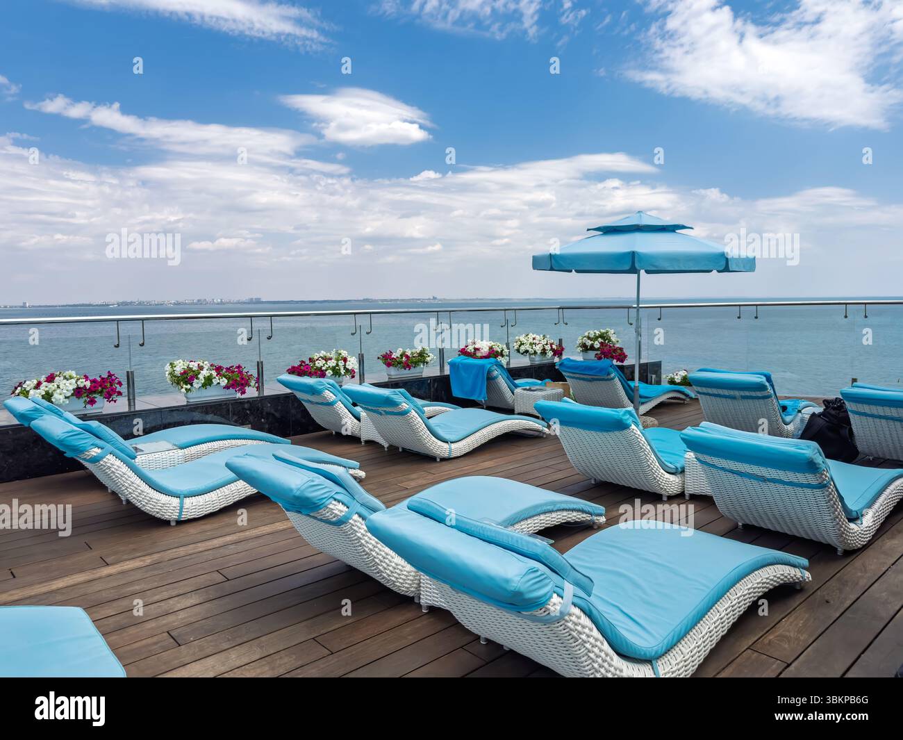 Scène idyllique de vacances d'été. Chaises longues vides sur une terrasse surplombant l'océan calme. Concept de voyage, d'évasion et de vacances sereines. Banque D'Images