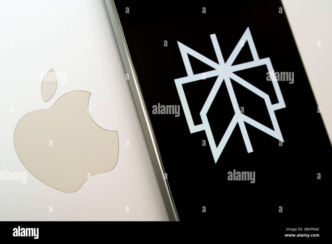 Logo perplexité sur smartphone à côté du logo Apple sur ordinateur portable. Banque D'Images