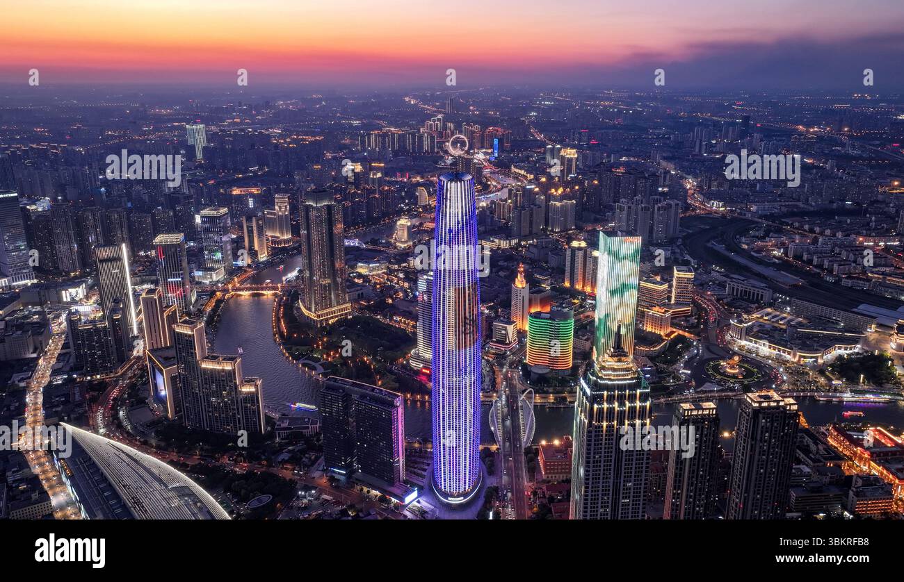 Pékin, Chine. 21 juin 2025. Une photo prise par un drone aérien le 21 juin 2025 montre le Tianjin World Financial Center (TWFC) à Tianjin, dans le nord de la Chine. La salle touristique 'le sommet de Tianjin' au 79ème étage du TWFC a officiellement ouvert au public dimanche. Les visiteurs peuvent maintenant profiter d'une vue panoramique à 360 degrés sur le paysage urbain de Tianjin depuis une hauteur de 310 mètres. Situé le long de la rivière Haihe dans la zone urbaine centrale de Tianjin, le TWFC atteint 336,9 mètres, ce qui en fait l'un des gratte-ciel les plus emblématiques de la ville depuis son achèvement en 2011. Crédit : Sun Fanyue/Xinhua/Alamy Live News Banque D'Images