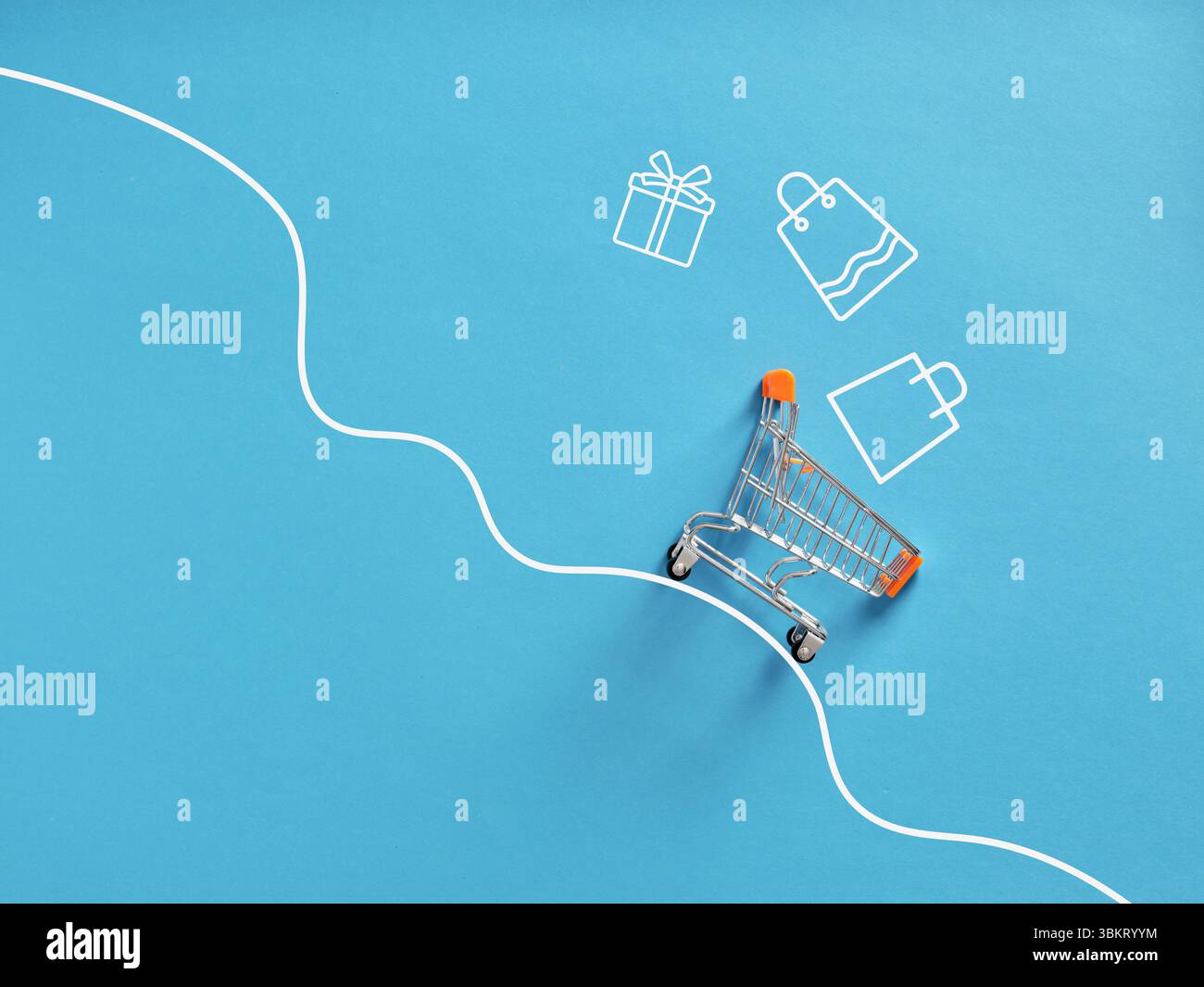 Chariot miniature glissant vers le bas d'une pente approchant des icônes de cadeau et de sac à provisions sur fond bleu, représentant les achats en ligne et le consumérisme Banque D'Images
