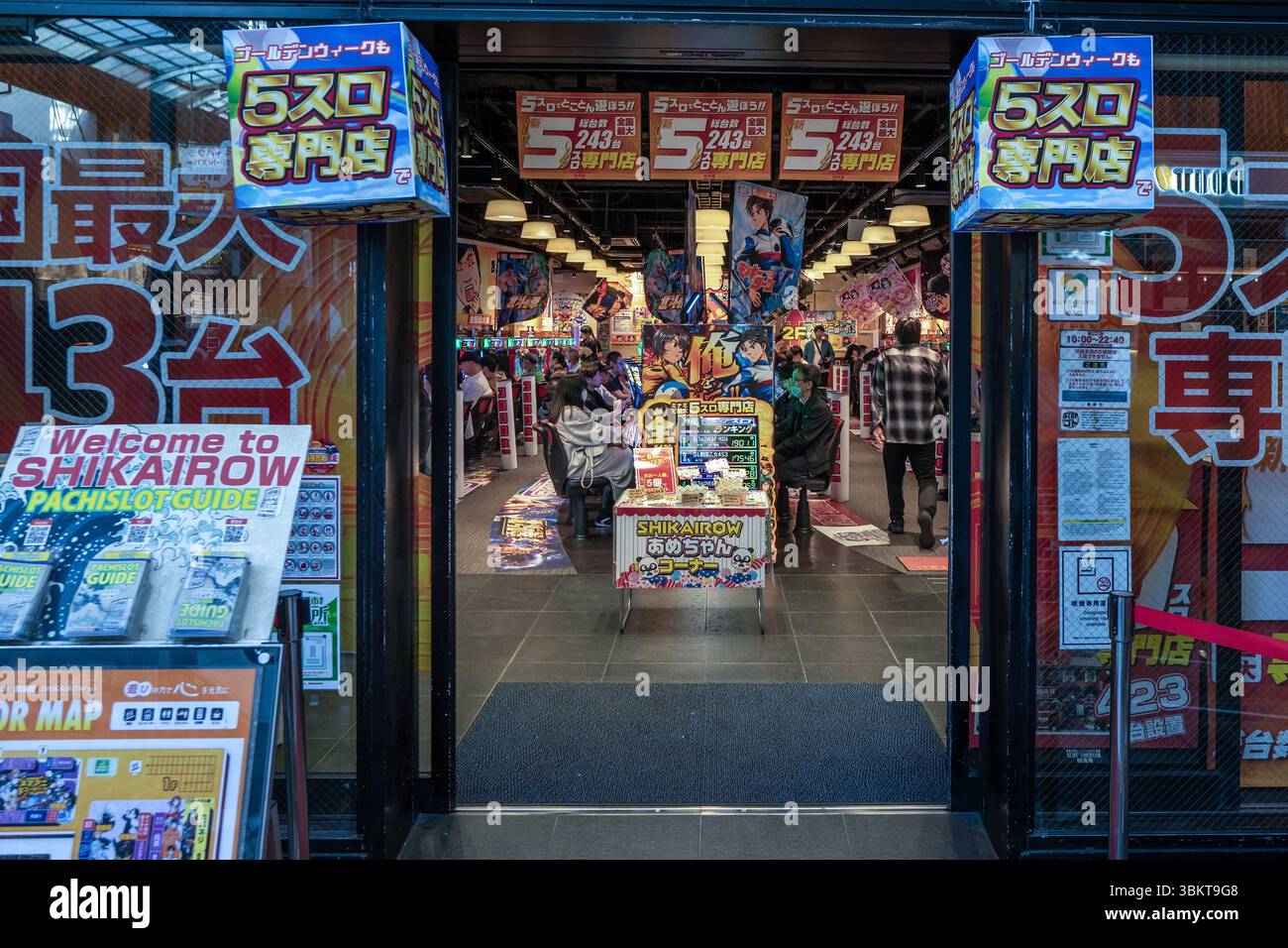 Les gens dans la salle de jeux d'arcade de machines à sous à Osaka, Japon. Banque D'Images