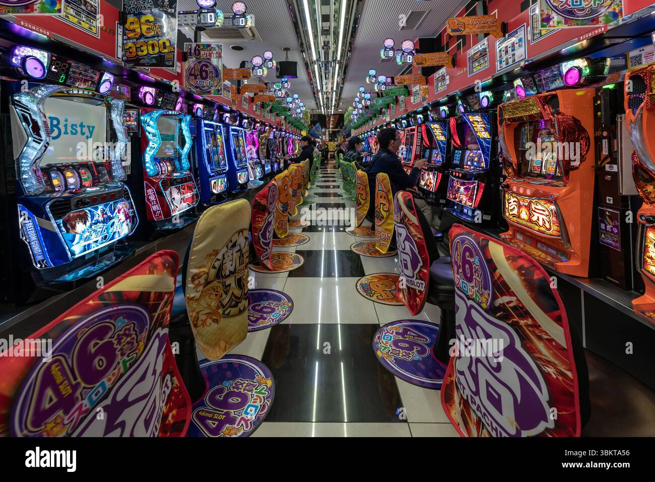 Les gens dans Pachinko jeu machine à sous arcade à Osaka, Japon. Le pachinko est un jeu populaire pour les loisirs et les jeux. Banque D'Images