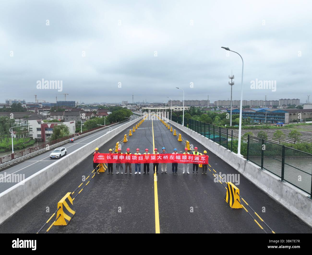Suzhou. 23 juin 2025. Une photo de drone montre des travailleurs posant pour des photos lors de l'ouverture des voies de gauche du pont de Pingwang nouvellement construit dans le district de Wujiang de la ville de Suzhou, dans la province du Jiangsu de l'est de la Chine, le 23 juin 2025. Les voies de gauche du pont de Pingwang nouvellement construit, un projet de la partie est du projet d'amélioration du canal de navigation de Chang-Hu-Shen (Changxin-Huzhou-Shanghai) (section Jiangsu), ont été officiellement ouvertes à la circulation lundi. Crédit : Ji Chunpeng/Xinhua/Alamy Live News Banque D'Images