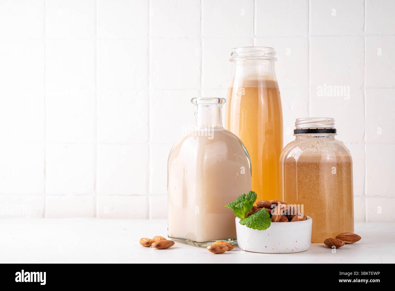 Sirop d'orgeat d'amande maison dans différentes bouteilles, amandes, eau, sucre et sirop d'eau de fleur d'oranger pour faire des cocktails sucrés Banque D'Images