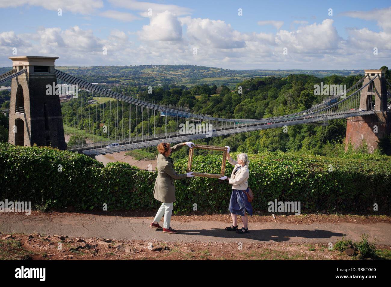 Les représentants du Bristol Museum & Art Gallery tiennent un cadre vide contre Avon gorge à Bristol, qui a été peint par JMW Turner dans The Rising Squall, Hot Wells, from St Vincent's Rock, Bristol (1792). Une campagne de collecte de fonds a été lancée pour ramener l’une des premières œuvres de Turner dans la ville de Bristol où l’artiste l’a peinte à l’âge de 17 ans. Bristol Museum & Art Gallery est maintenant désireux d'acquérir l'œuvre, qui est considérée comme la seule peinture à l'huile Turner faite de la ville. Date de la photo : lundi 23 juin 2025. Banque D'Images