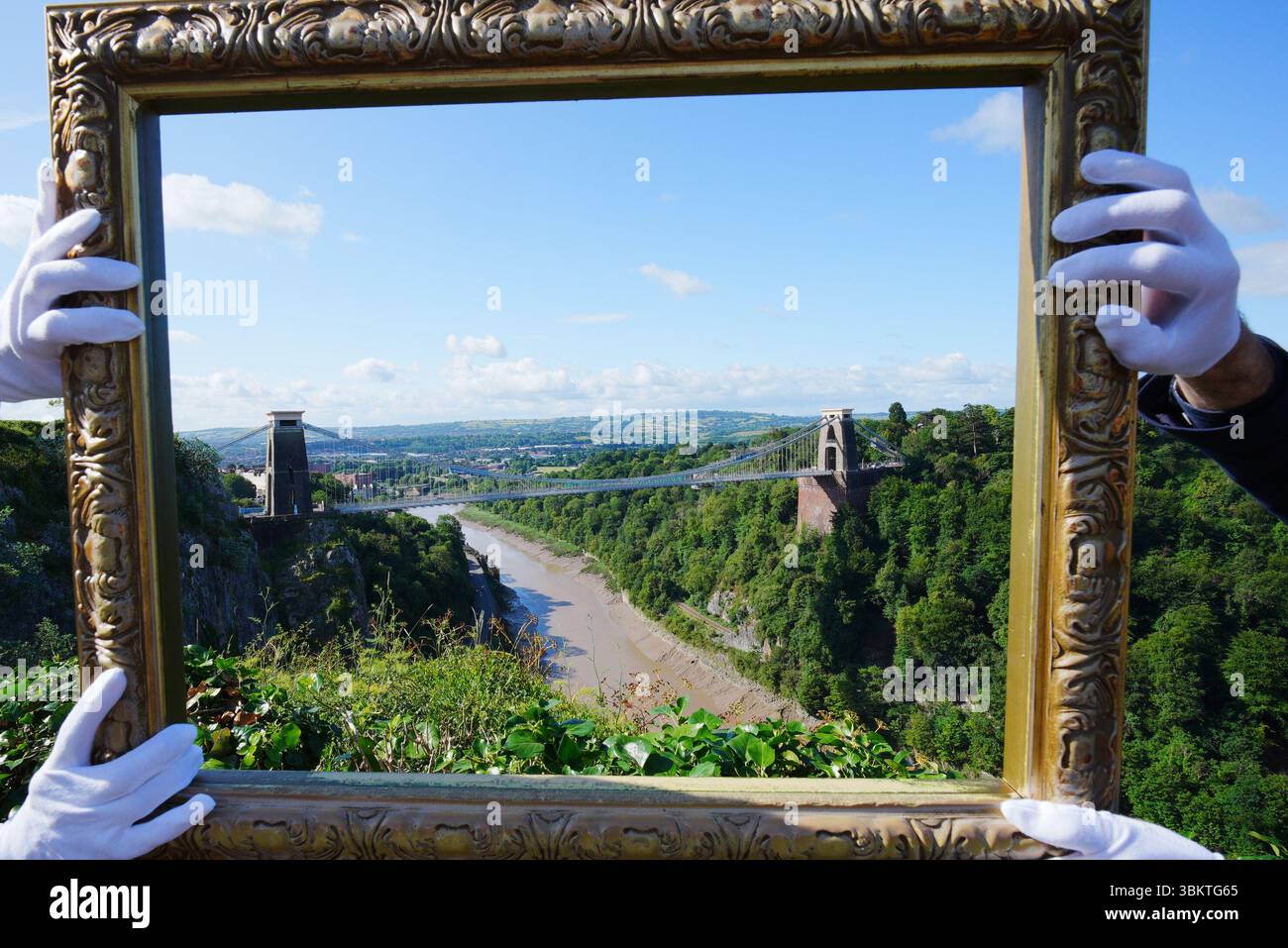 Les représentants du Bristol Museum & Art Gallery tiennent un cadre vide contre Avon gorge à Bristol, qui a été peint par JMW Turner dans The Rising Squall, Hot Wells, from St Vincent's Rock, Bristol (1792). Une campagne de collecte de fonds a été lancée pour ramener l’une des premières œuvres de Turner dans la ville de Bristol où l’artiste l’a peinte à l’âge de 17 ans. Bristol Museum & Art Gallery est maintenant désireux d'acquérir l'œuvre, qui est considérée comme la seule peinture à l'huile Turner faite de la ville. Date de la photo : lundi 23 juin 2025. Banque D'Images