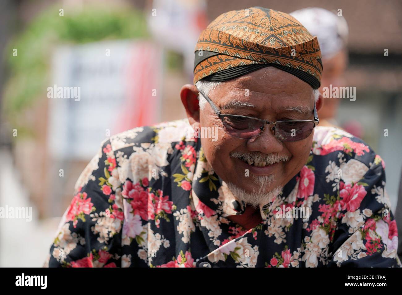 Un vieil homme souriant portant le batik javanais traditionnel et le blangkon pendant le défilé culturel de Kirab Budaya Ngabean 2024 dans le centre de Java, en Indonésie Banque D'Images