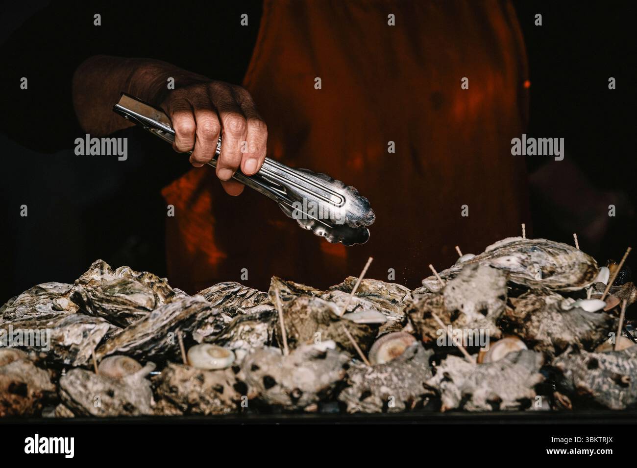 Femme griller des coquilles de turban à Matsushima, Japon. Banque D'Images