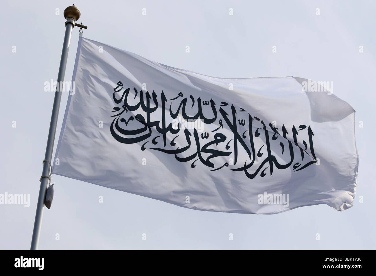 Le drapeau national de l'Émirat islamique d'Afghanistan, les talibans, flottant dans le vent sur un mât de drapeau à Saint-Pétersbourg, en Russie. Banque D'Images