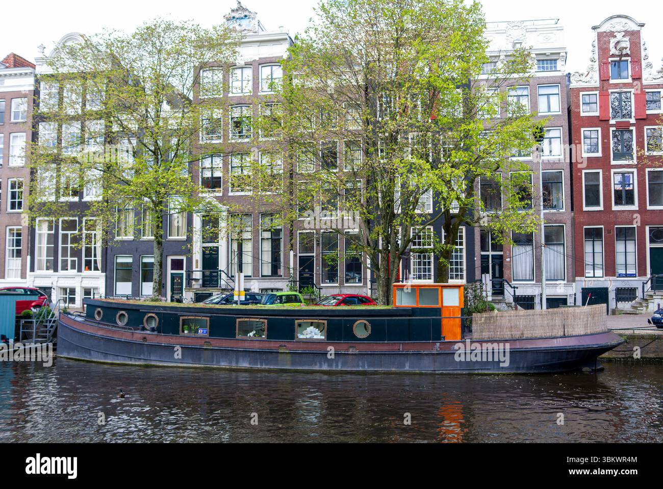 Amsterdam Living : une péniche amarrée sur un canal, présentant un mode de vie unique au milieu du charme historique de la ville. Banque D'Images