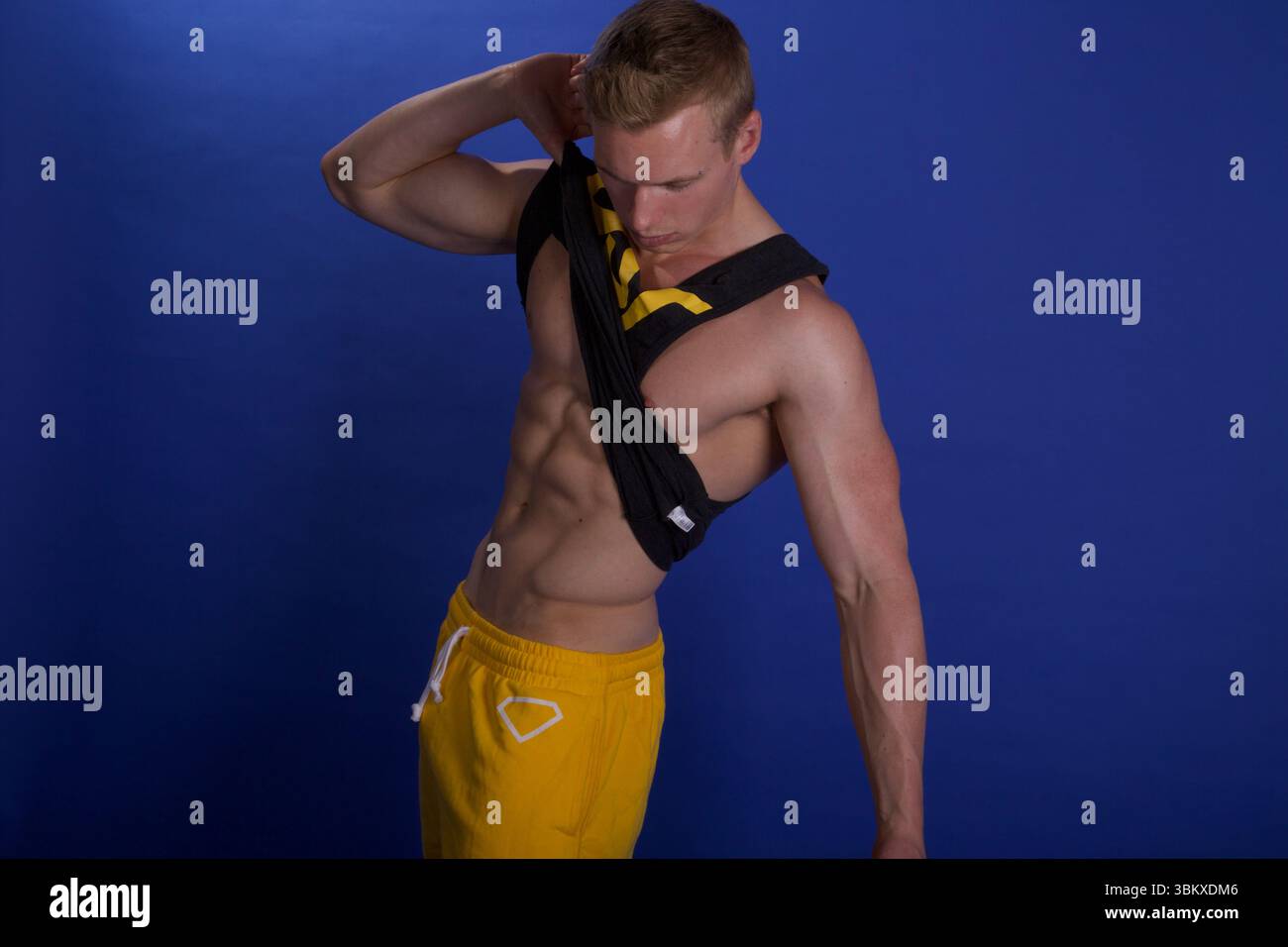 Homme soulevant son débardeur Banque D'Images