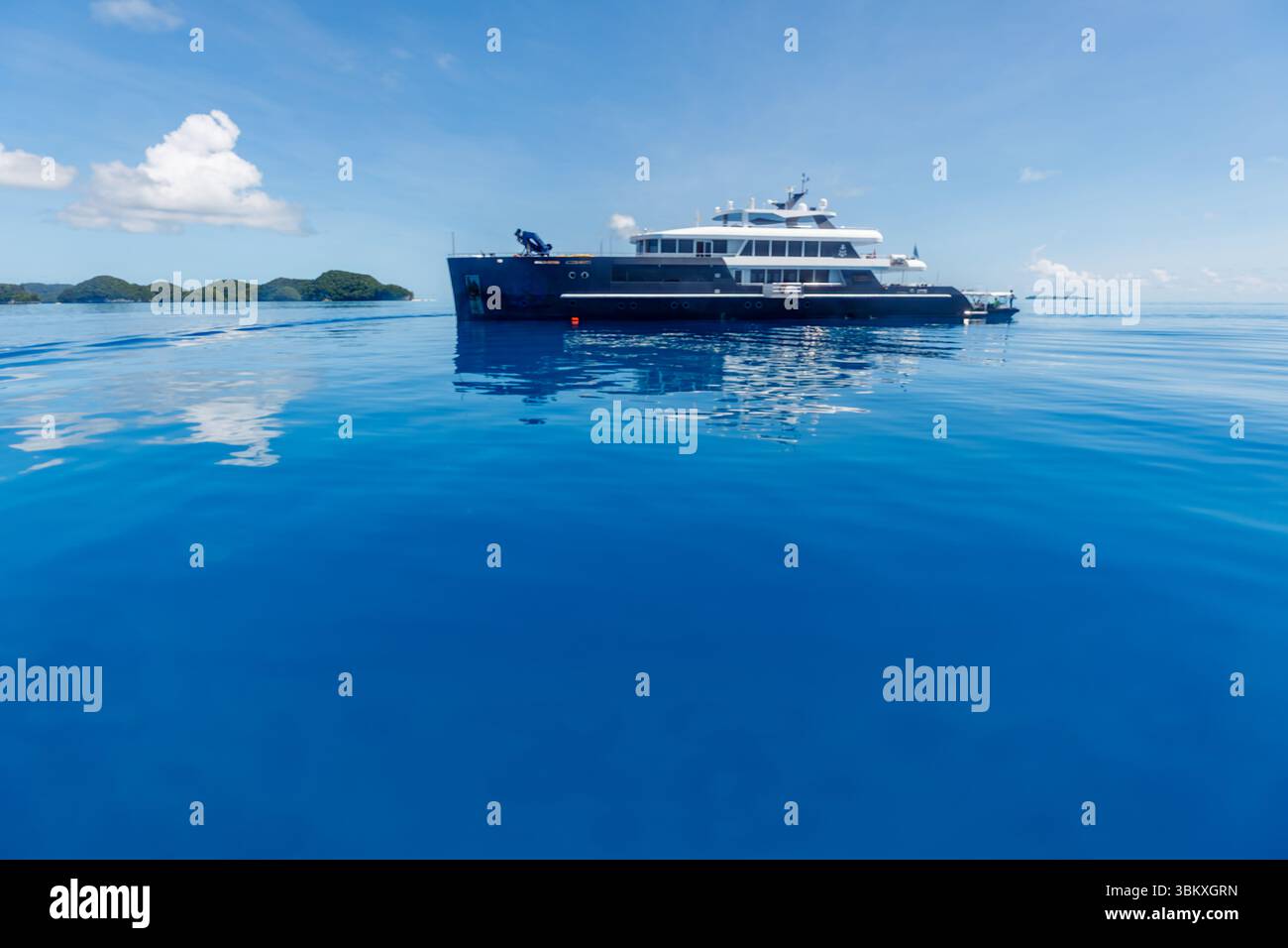 Un yacht de luxe est ancré dans les eaux calmes et bleues d'un endroit tropical, peut-être pour une croisière tranquille ou l'exploration des îles environnantes. Banque D'Images Un yacht de luxe est ancré dans les eaux calmes et bleues d'un endroit tropical, peut-être pour une croisière tranquille ou l'exploration des îles environnantes. Banque D'Images