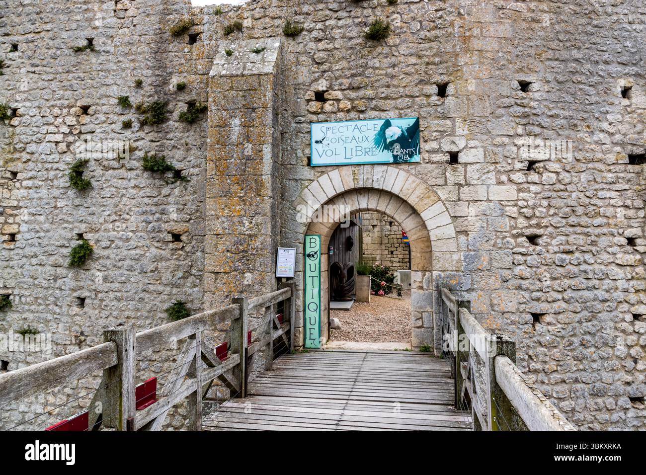 Entrée au parc d’expositions ornithologiques dans le complexe médiéval du château de Chauvigny (Nouvelle-Aquitaine, France) : un pont-levis en bois passe par un arc rond roman ; un panneau au-dessus de la porte annonce le « spectacle oiseaux vol libre ». Dans la haute-ville de Chauvigny, des expositions en vol libre mettant en vedette des oiseaux de proie et des oiseaux sauvages ont lieu quotidiennement parmi les ruines du Château Baron Banque D'Images