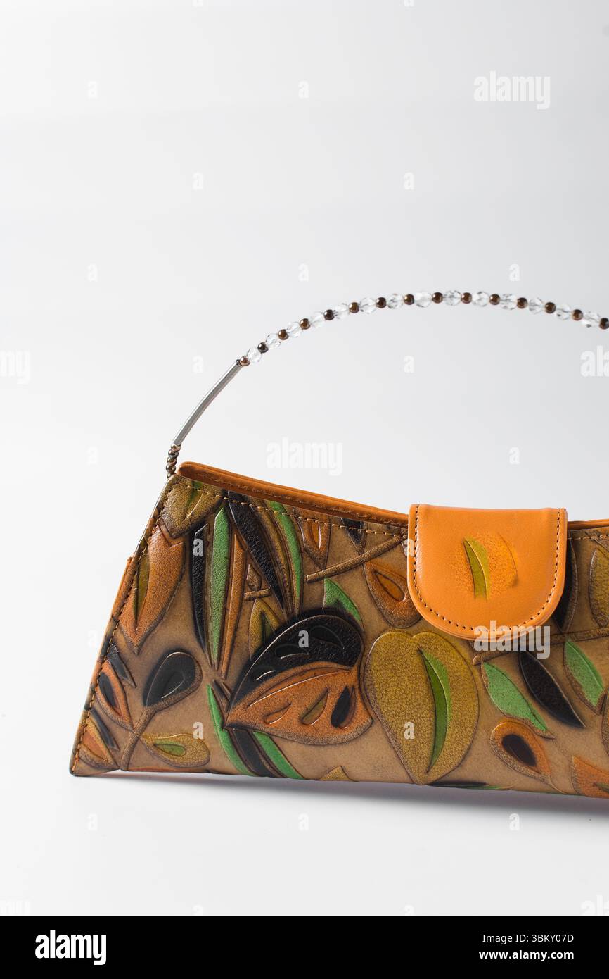 Sac à main orange fait à la main sur un fond blanc, sac à main en cuir orange fait à la main, sac à main artisanal en or orange avec une poignée courte en chaîne Banque D'Images