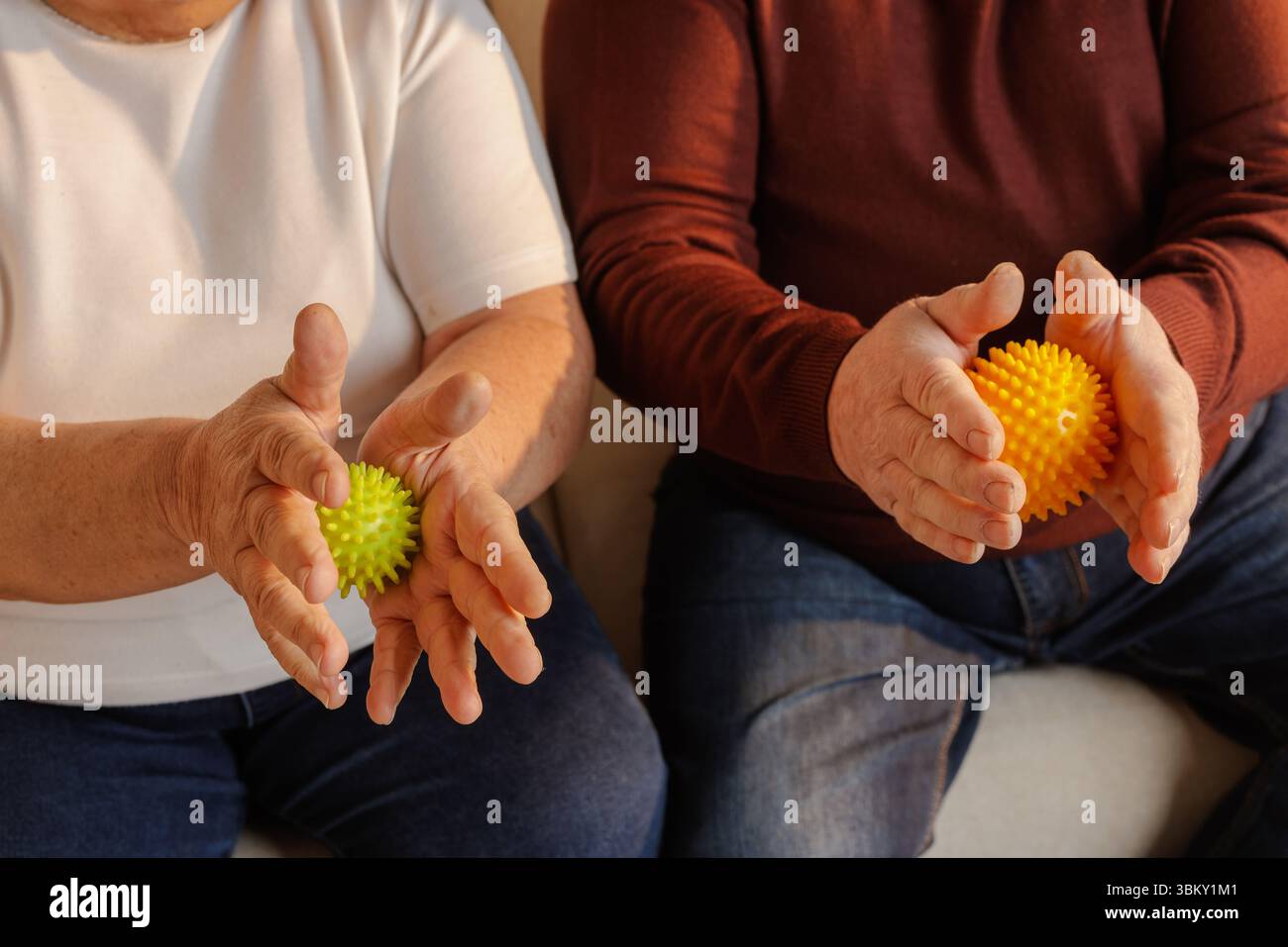Couple de personnes âgées utilisant des balles de massage spiky pour l'exercice de la main soulagement de la douleur, réhabilitation et soutien de bien-être à la maison Banque D'Images