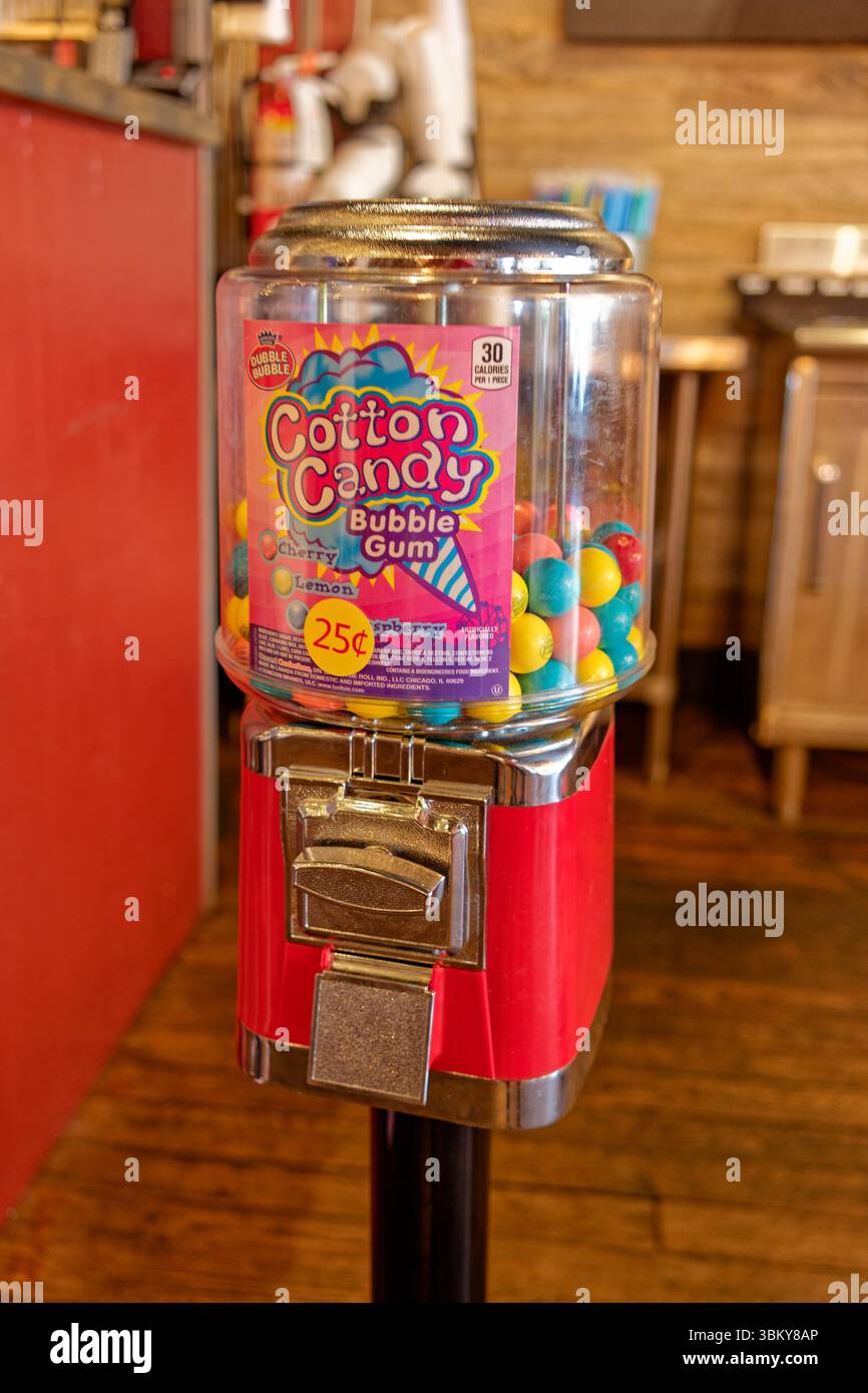 Machine à gomme bulle rouge vif vintage avec une grande saveur de barbe à papa double bulle gomme à l'intérieur pour .25 cents dans un gros plan de magasin Banque D'Images