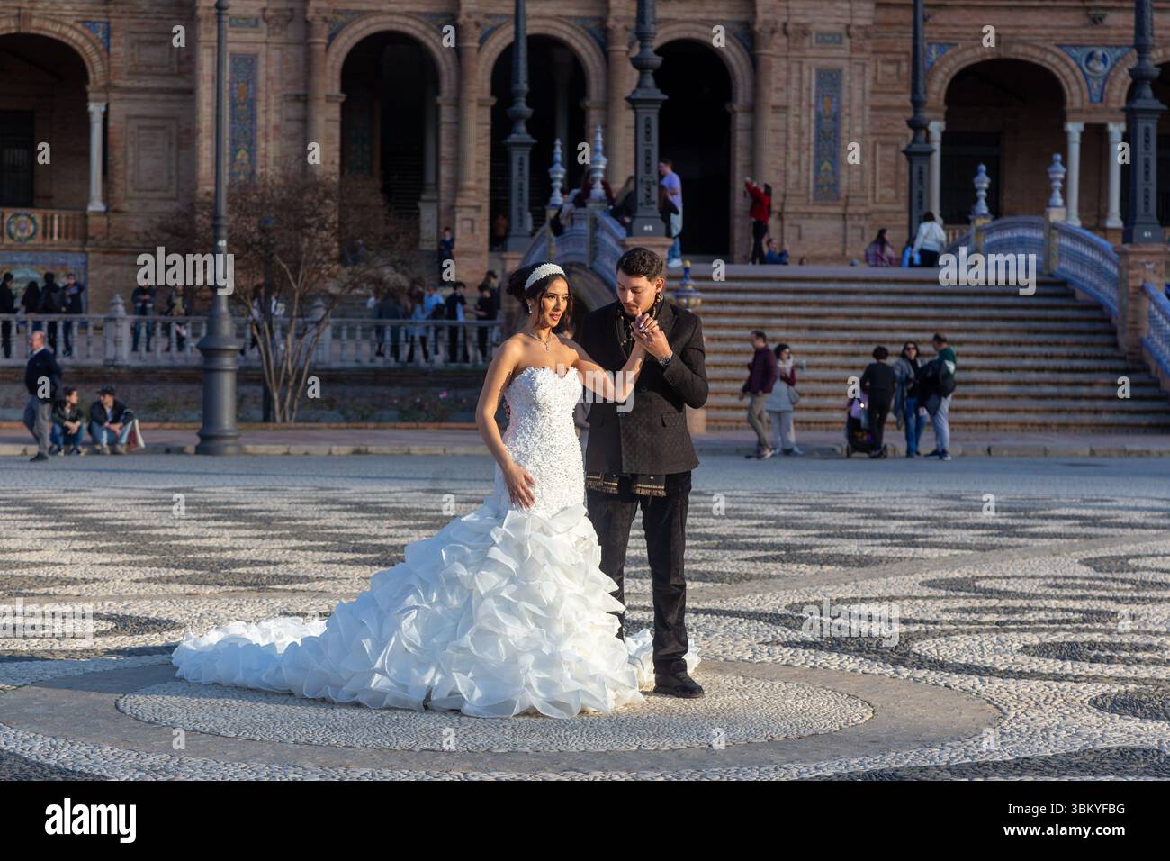 Couple espagnol dans l'amour engagement Beautiful bride longue robe de mariée blanche Handsome Groom costume noir. Plaza de Espana, Séville Andalousie Espagne Banque D'Images
