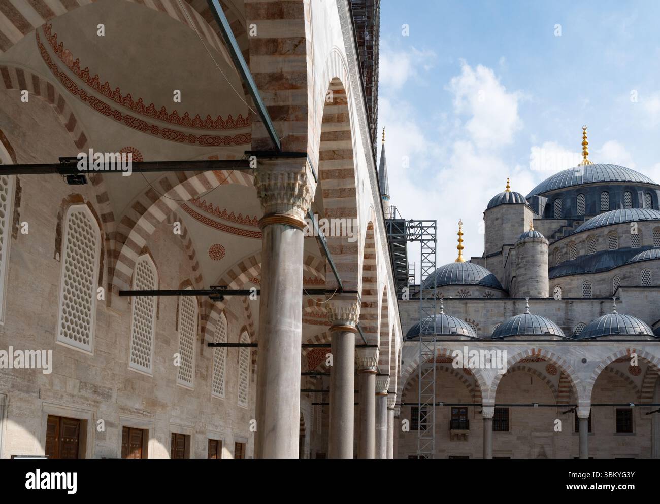 Une vue de la Mosquée bleue à Istanbul, en Turquie, montrant ses détails architecturaux tels que des dômes, des arches et des colonnes, avec des échafaudages indiquant des travaux d'entretien ou de restauration en cours. Banque D'Images Une vue de la Mosquée bleue à Istanbul, en Turquie, montrant ses détails architecturaux tels que des dômes, des arches et des colonnes, avec des échafaudages indiquant des travaux d'entretien ou de restauration en cours. Banque D'Images