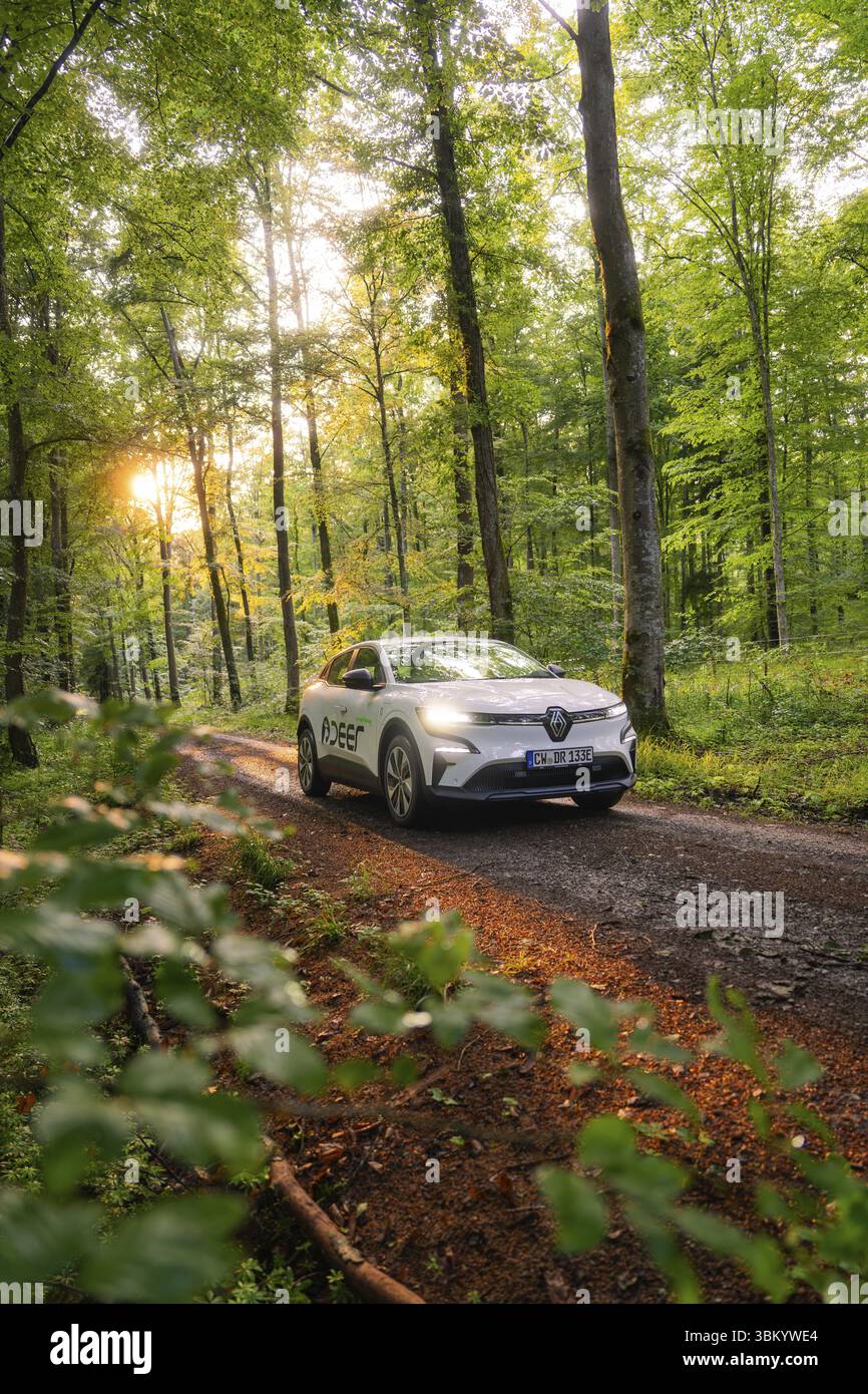 Renault sur un chemin forestier, environnement forestier vert inondé de soleil, Deer E- carsharing, Renault Megane voiture électrique, Calw, Forêt Noire, Allemagne Banque D'Images