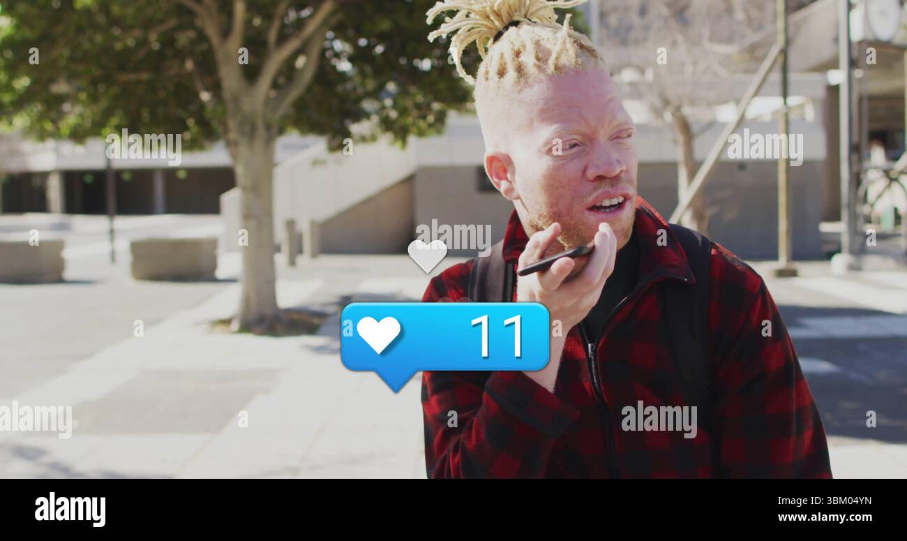 Homme portant une veste à carreaux parlant dans un smartphone dans la place urbaine, avec l'icône de coeur 11, espace de copie Banque D'Images