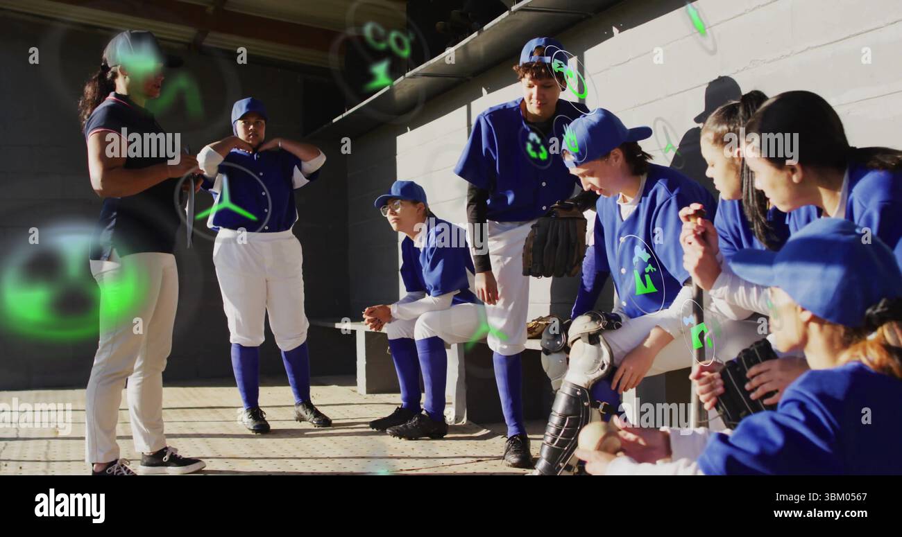 Rassemblement de l'entraîneur et de l'équipe de softball dans un dugout en béton, avec des gants et une batte Banque D'Images