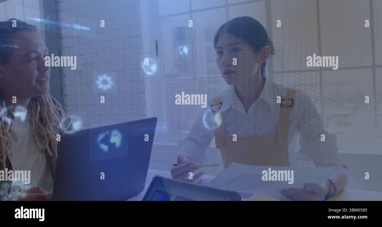 Discuter des collègues examinant des documents au bureau, avec un ordinateur portable, un haut-parleur et des données holographiques Banque D'Images