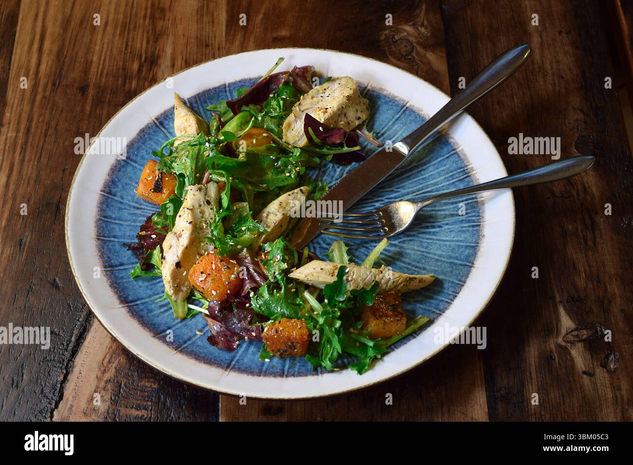 Salade avec poulet grillé, salade verte fraîche et courge rôtie Banque D'Images