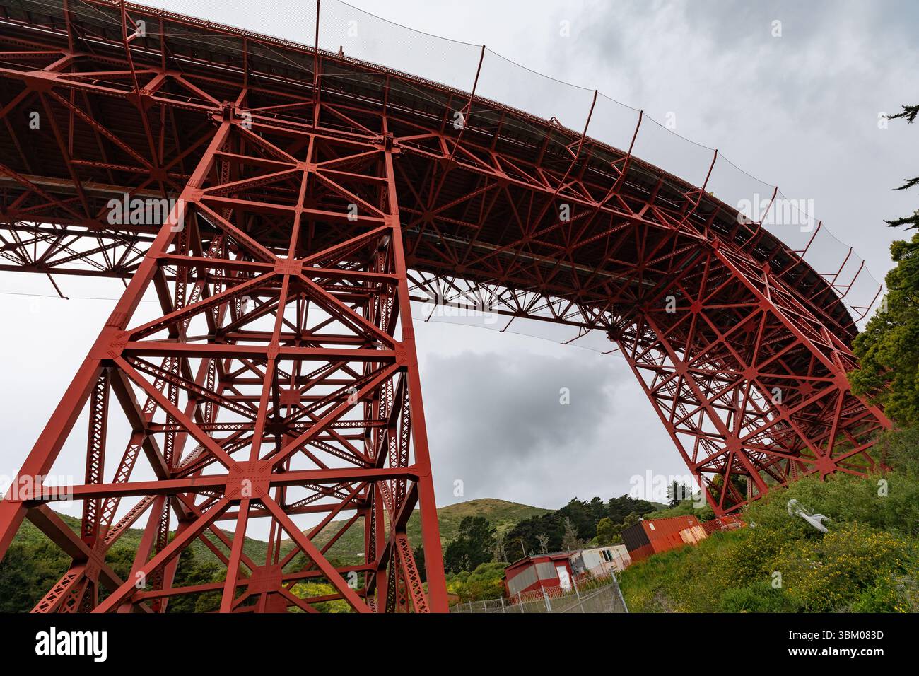 Une vue en bas angle de la structure en acier rouge du Golden Gate Bridge contre un ciel nuageux, mettant en valeur sa conception et son ingénierie complexes. Banque D'Images Une vue en bas angle de la structure en acier rouge du Golden Gate Bridge contre un ciel nuageux, mettant en valeur sa conception et son ingénierie complexes. Banque D'Images