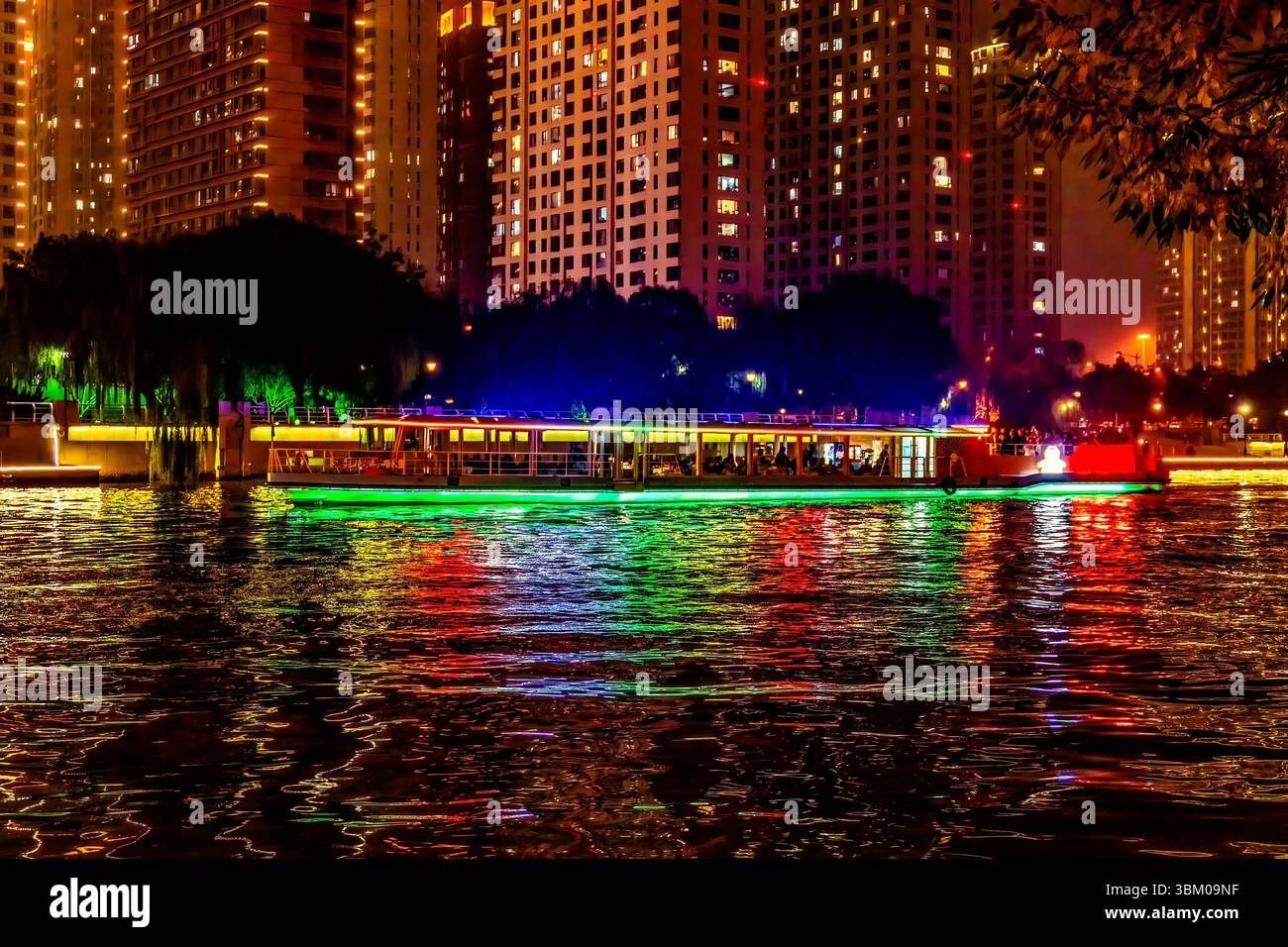 Bateau touristique coloré, réflexion de l'eau de la rivière Hai du pont illuminé, Tianjin, Chine. Banque D'Images
