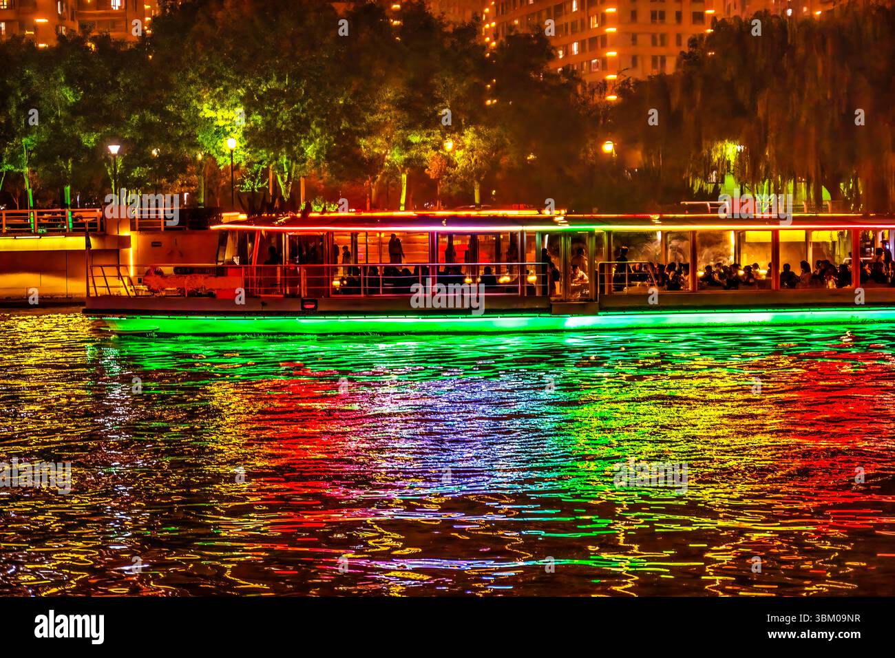 Bateau touristique coloré, réflexion de l'eau de la rivière Hai du pont illuminé, Tianjin, Chine. Banque D'Images