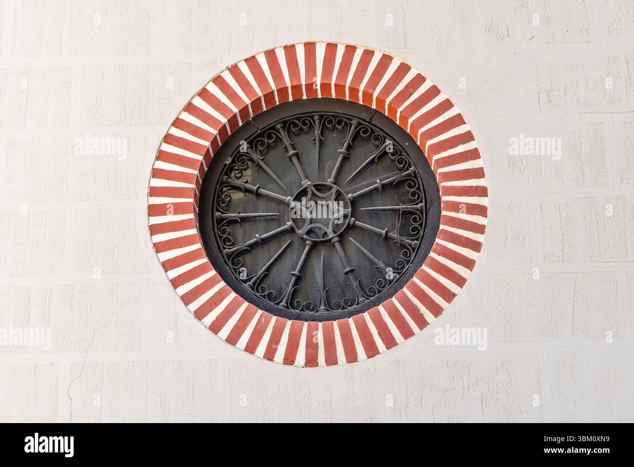 Albaicin, Province de Grenade, Andalousie, Espagne. Une fenêtre rosette entourée de bandes rouges et blanches. Banque D'Images