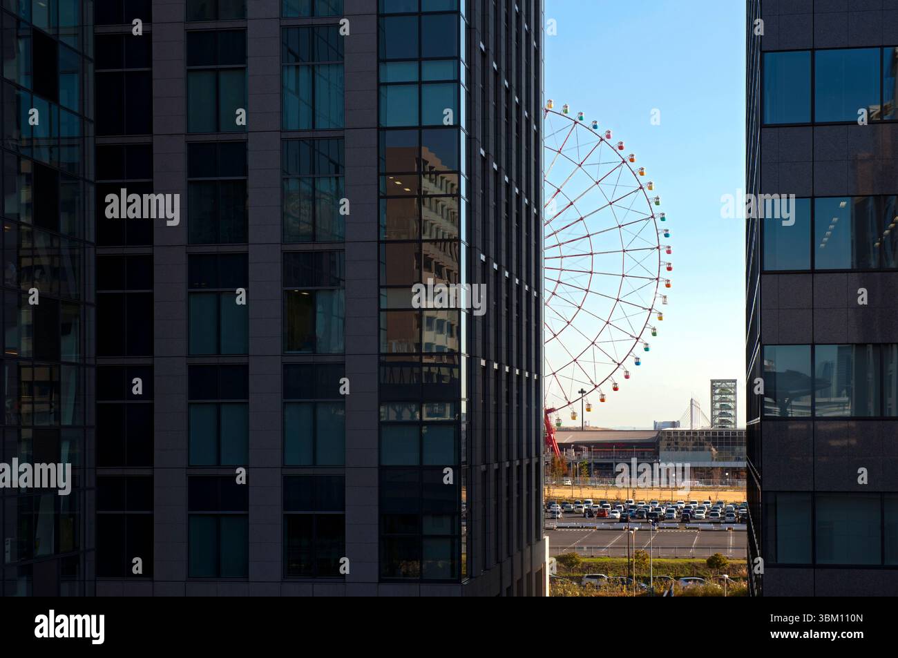 Vue panoramique entre les bâtiments de l'ancienne daikanransha de 115 mètres de haut (autrefois la plus grande grande roue du monde) à palette Town, Odiaba, Tokyo, Japon. Banque D'Images